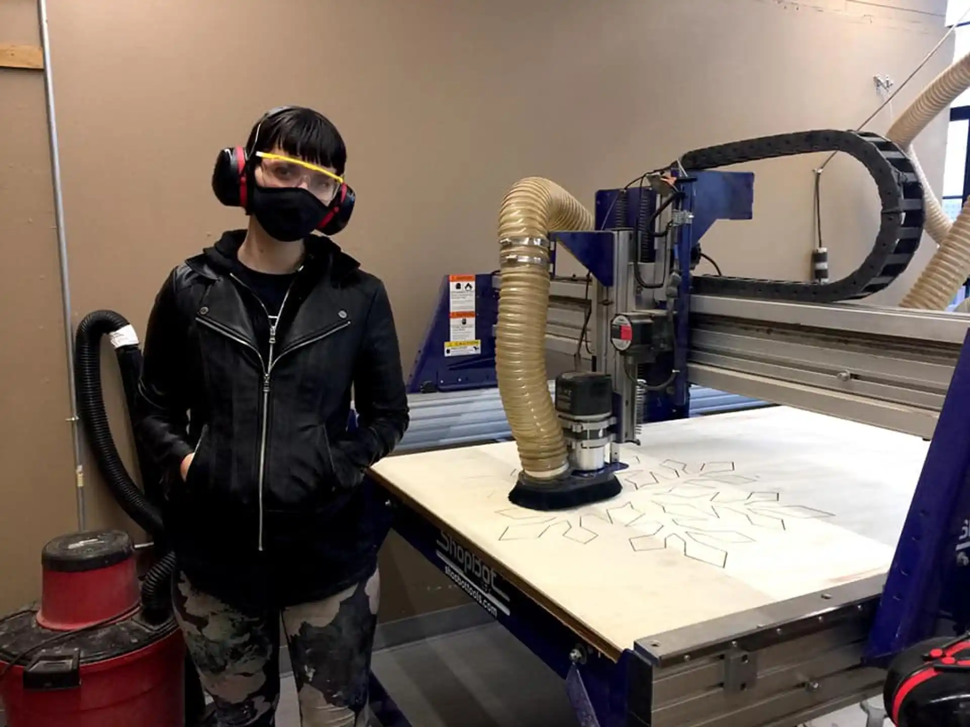a person wearing headphones and standing next to a table with a machine