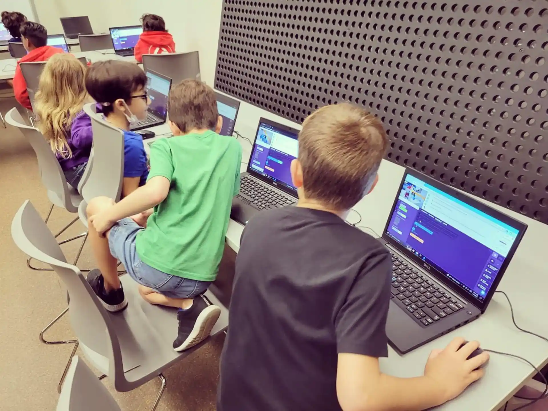 a group of people sitting at desks using laptops