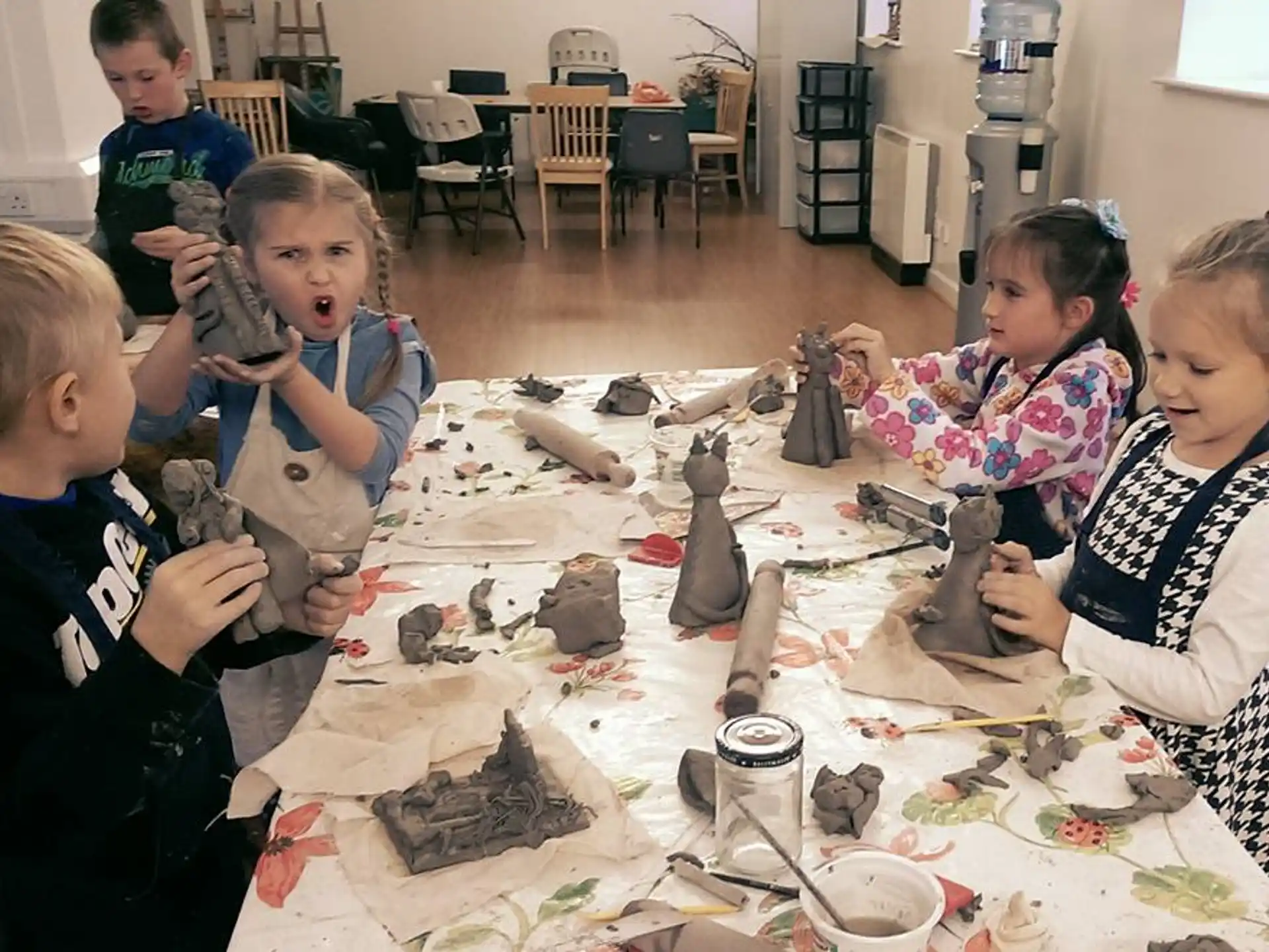 a group of children sitting around a table with objects on it