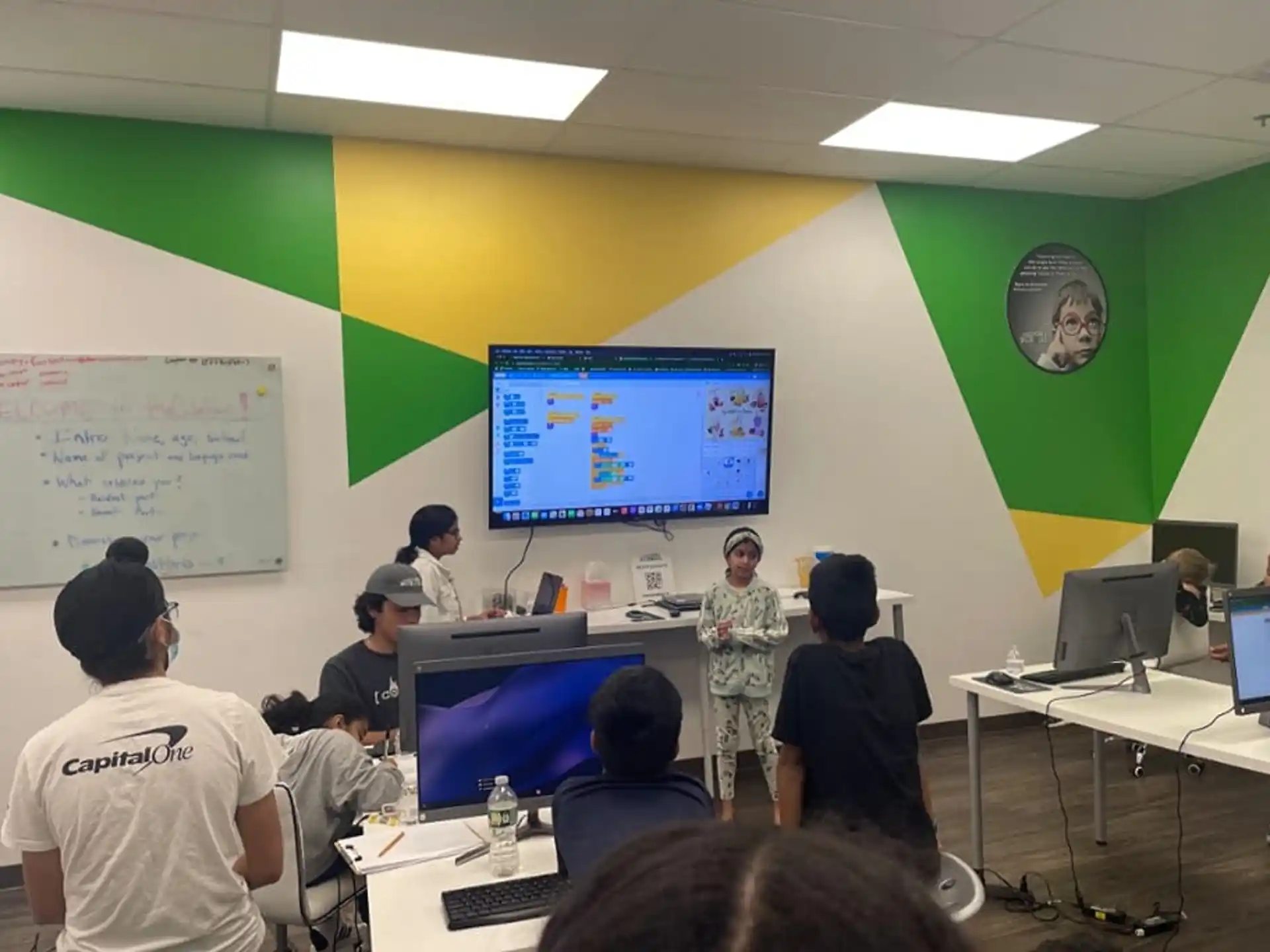 a group of people in a room with computers and a projection screen