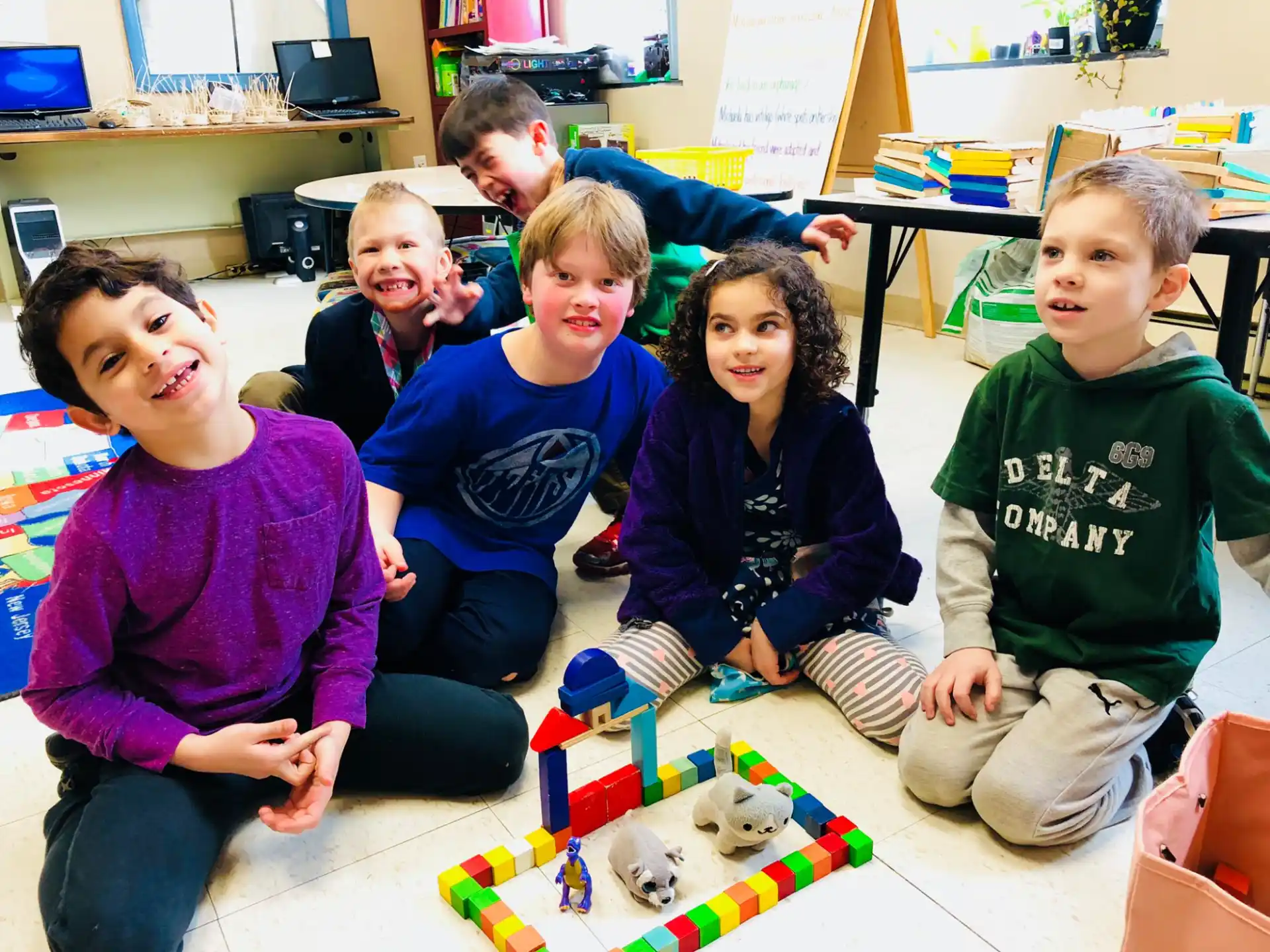 a group of children sitting on the floor with a puzzle