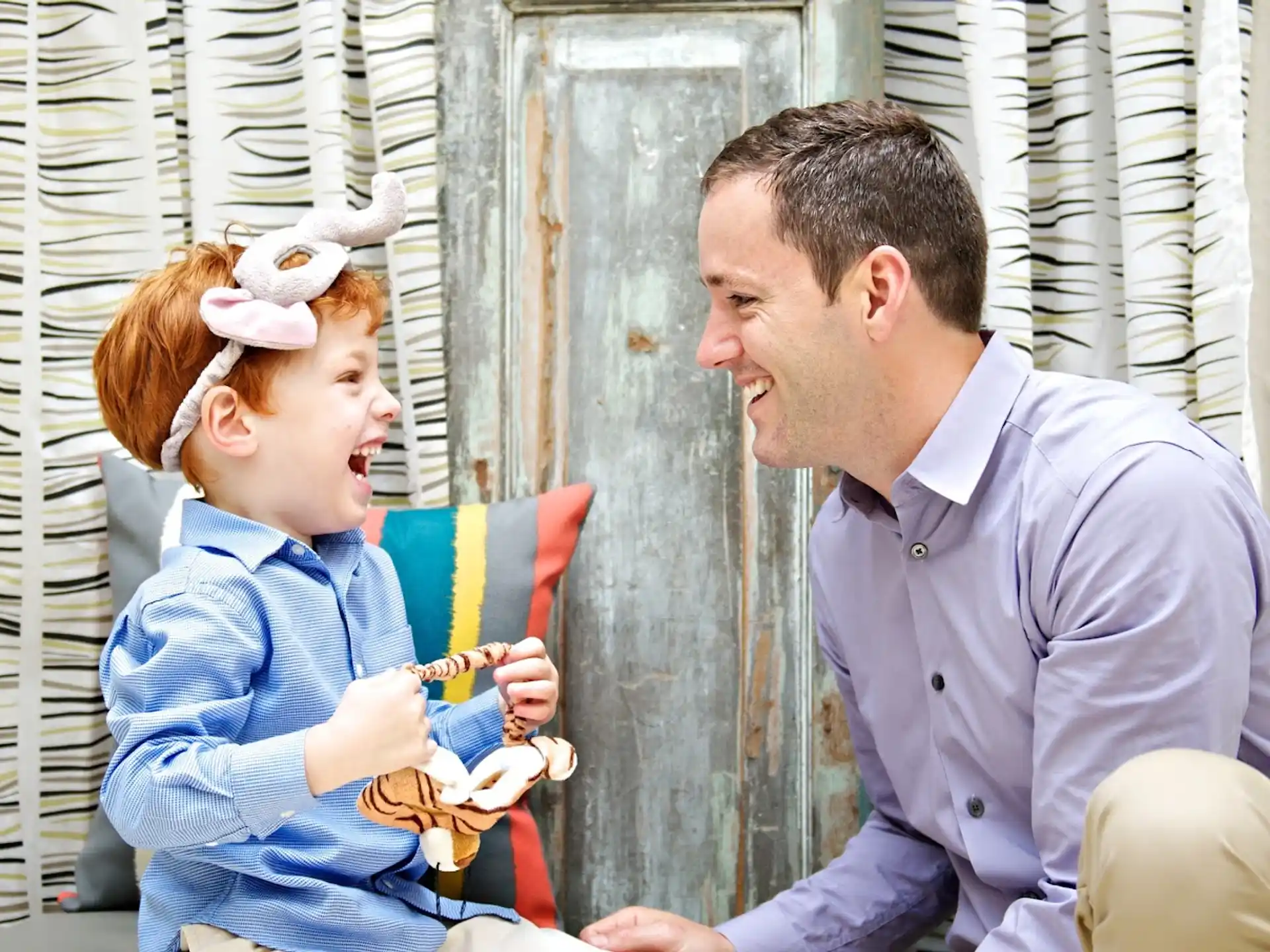 a man and a child holding a stuffed animal