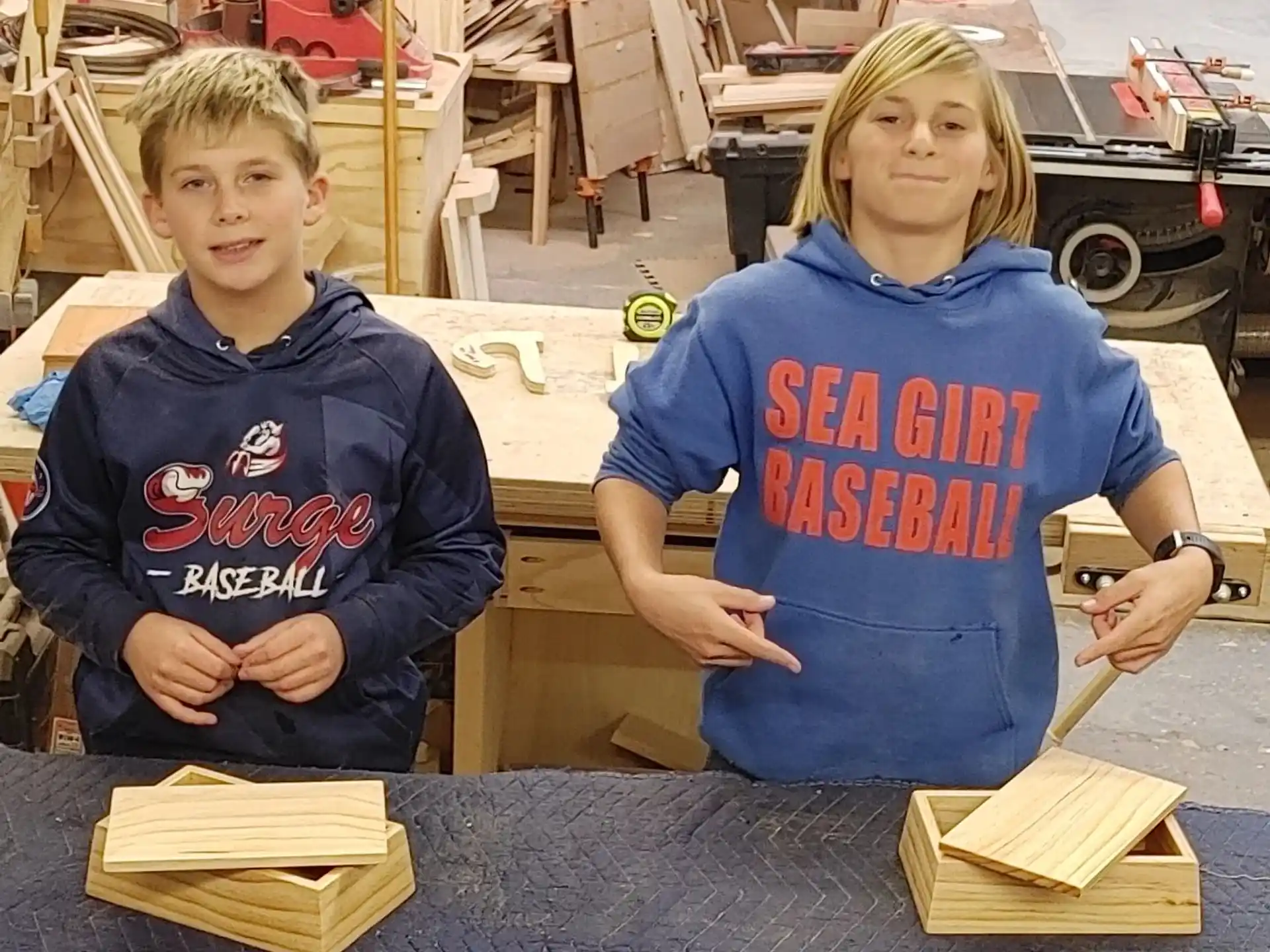 a couple of kids sitting at a table with wood blocks