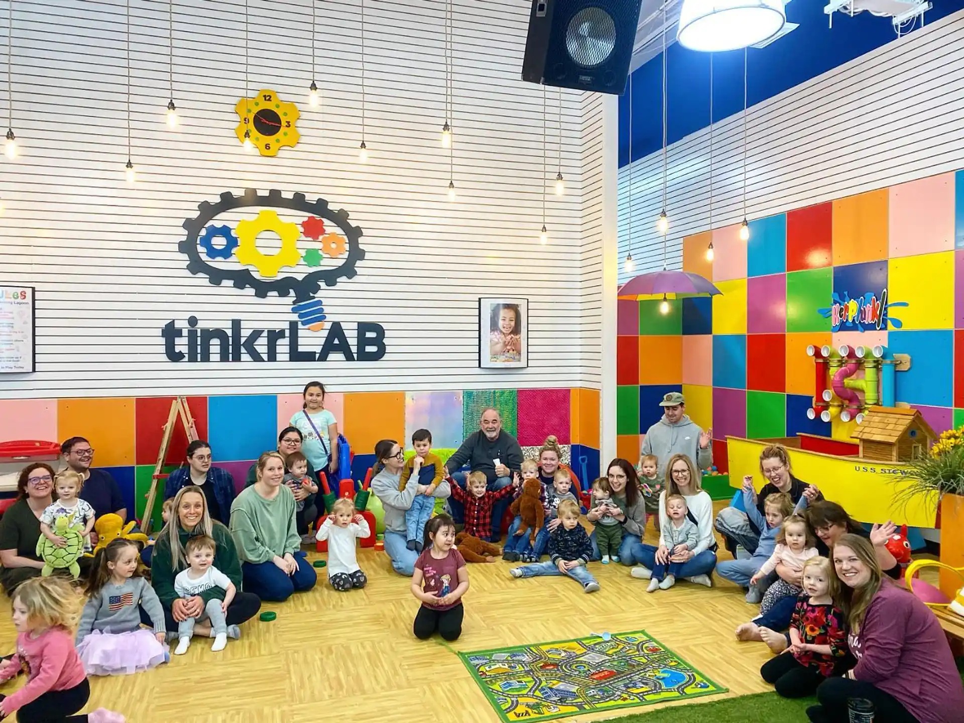 a group of people sitting on the floor in front of a stage