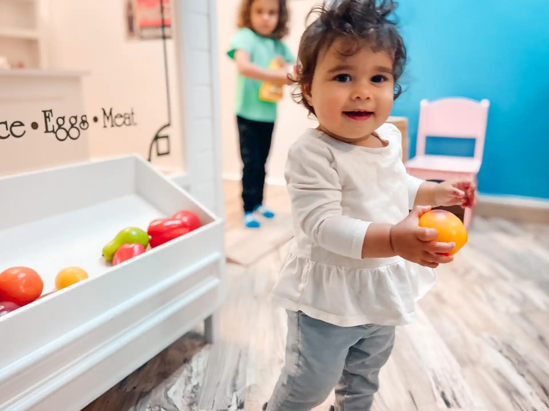 a young girl holding an orange
