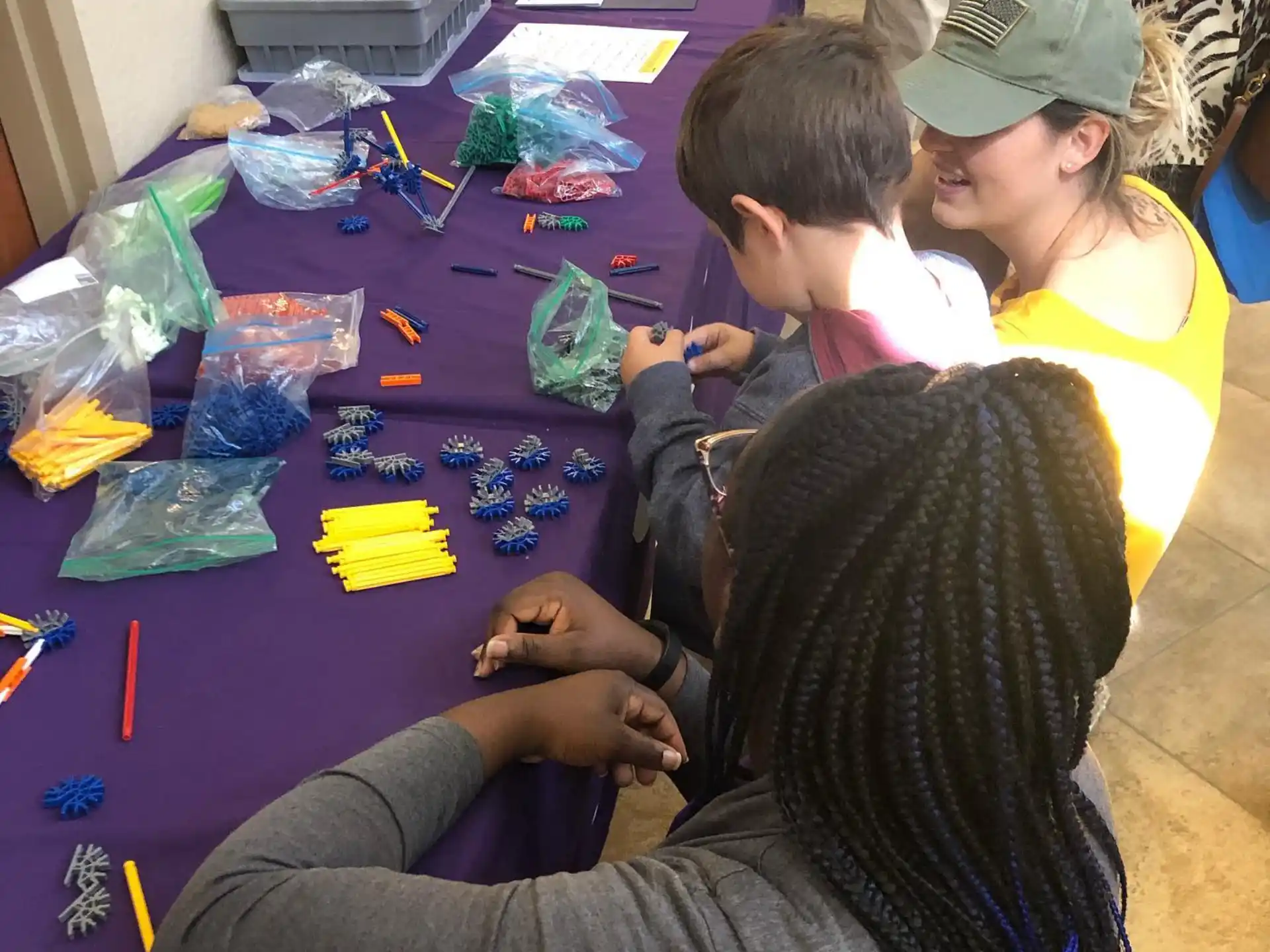 a group of people sitting at a table with colorful objects on it