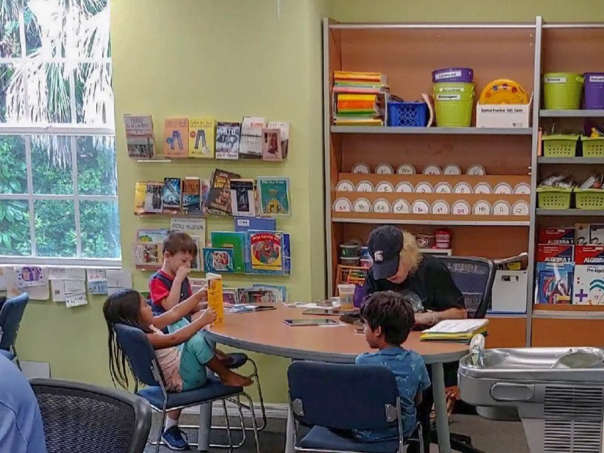a group of people sitting at a table with laptops