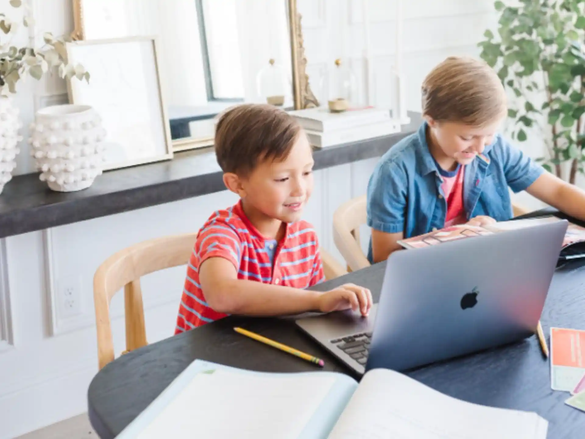 a couple of boys looking at a laptop