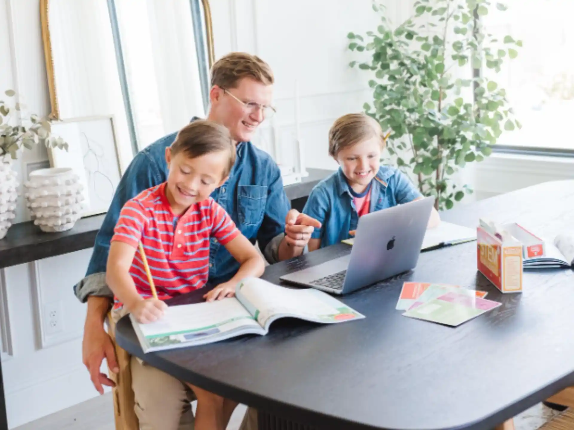 a group of people sitting at a table looking at a laptop