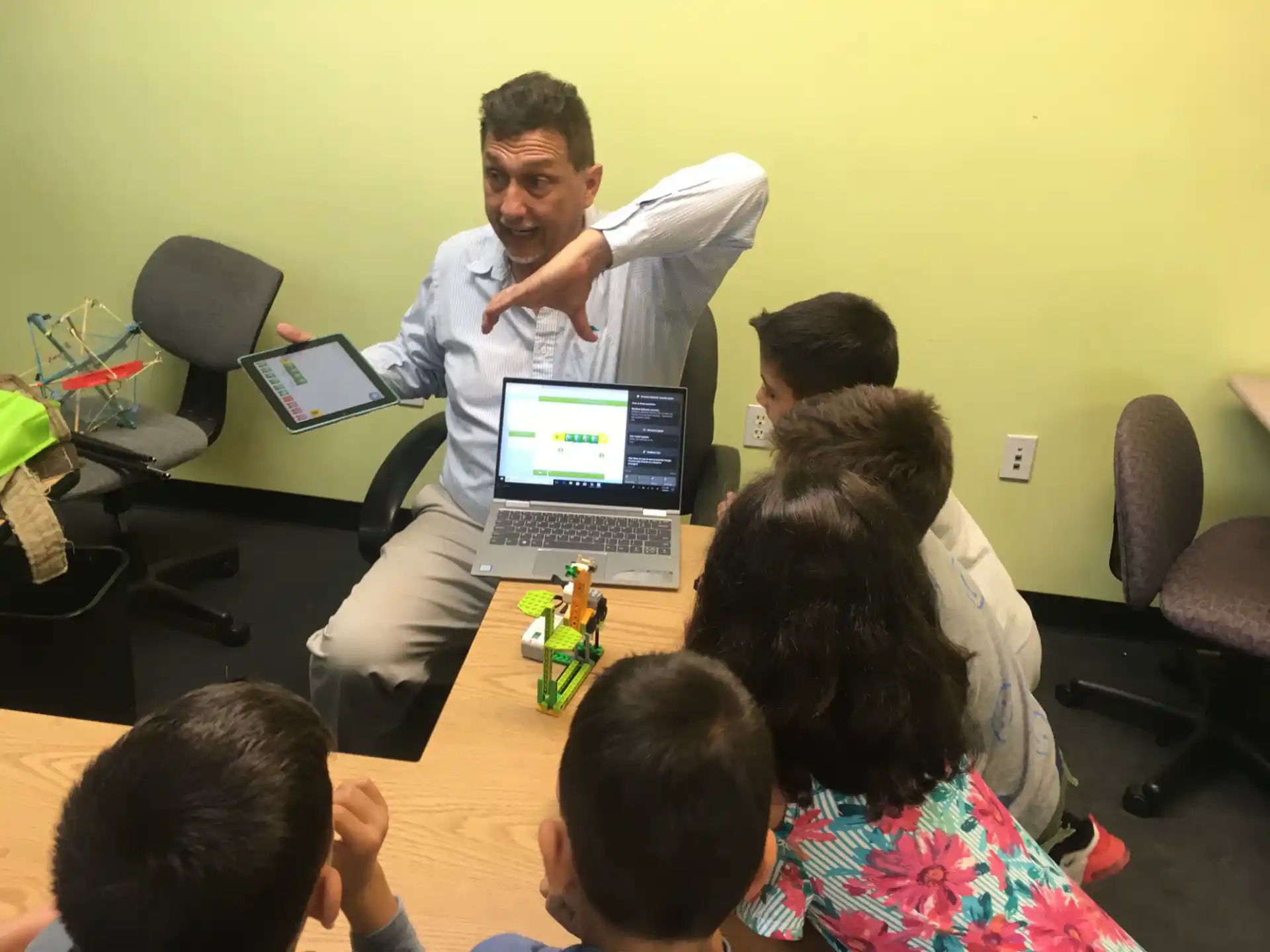 a man standing in front of a table with a group of kids