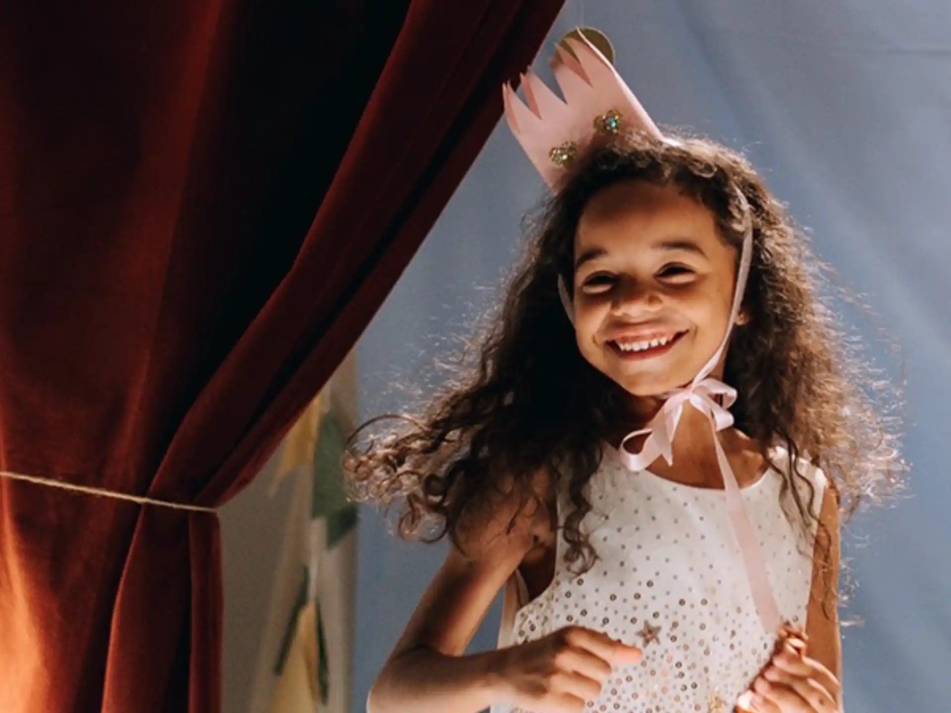 a girl wearing a white dress and crown