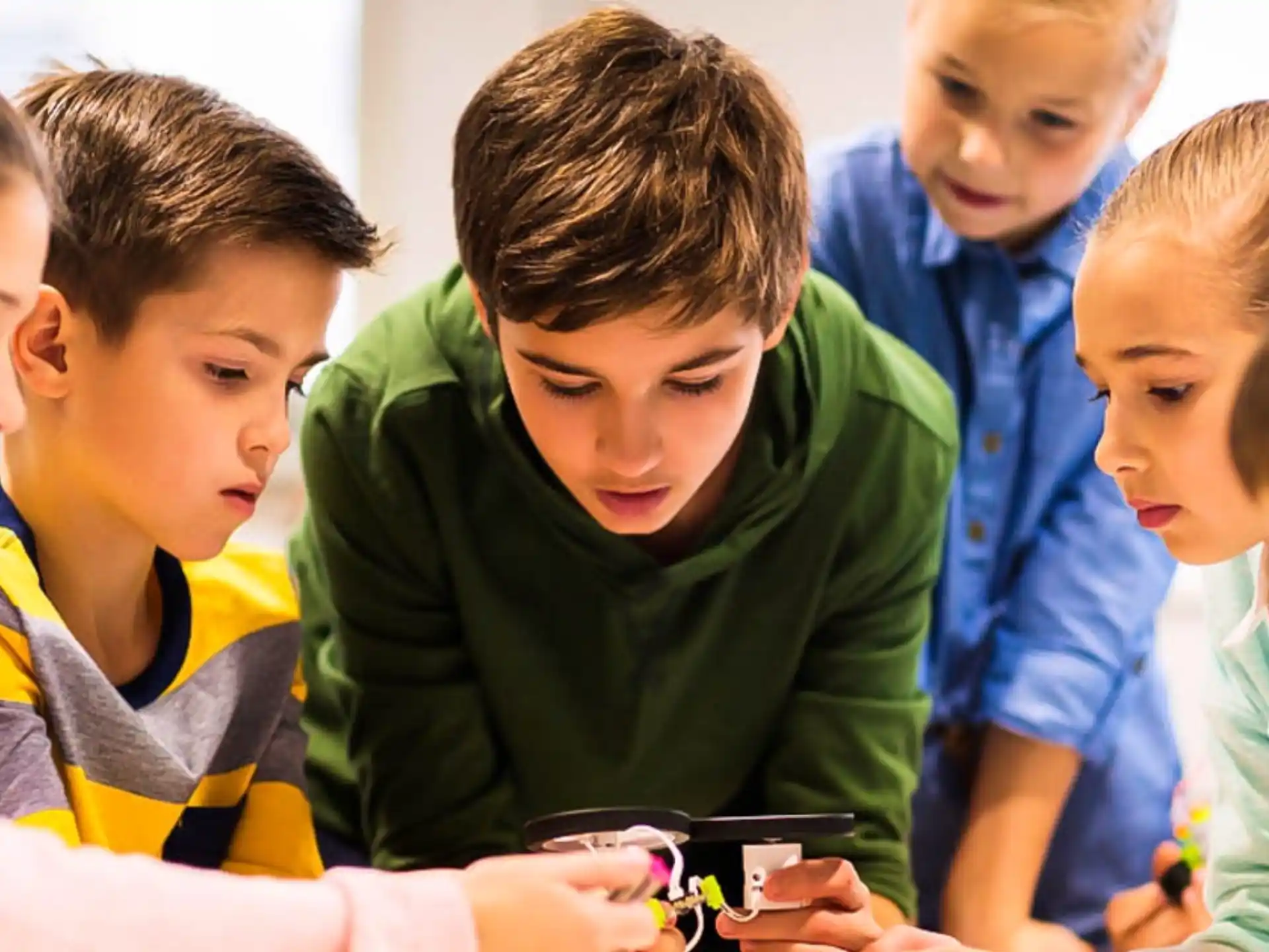 a group of children looking at a phone