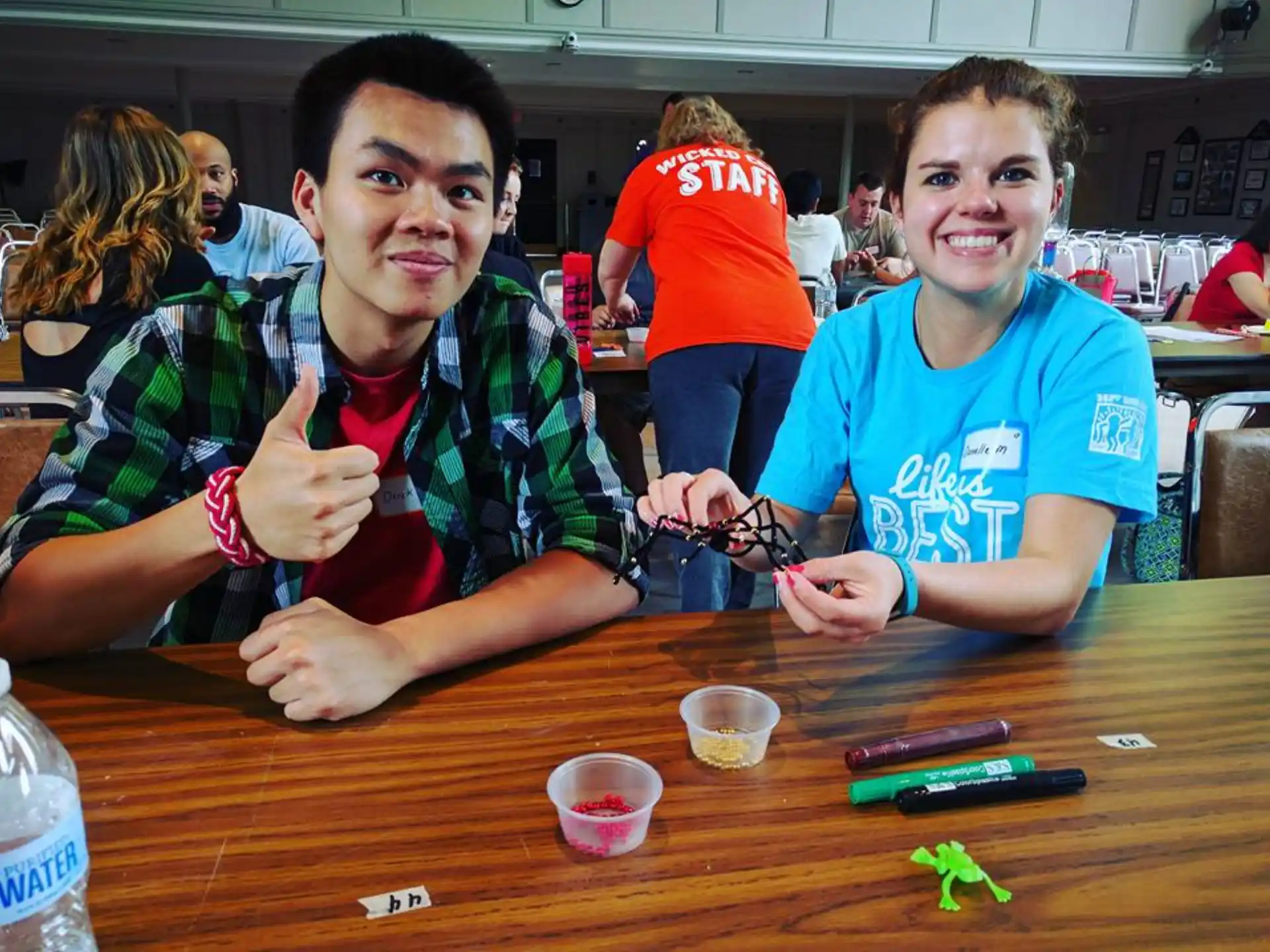 a couple of boys sitting at a table with a toy