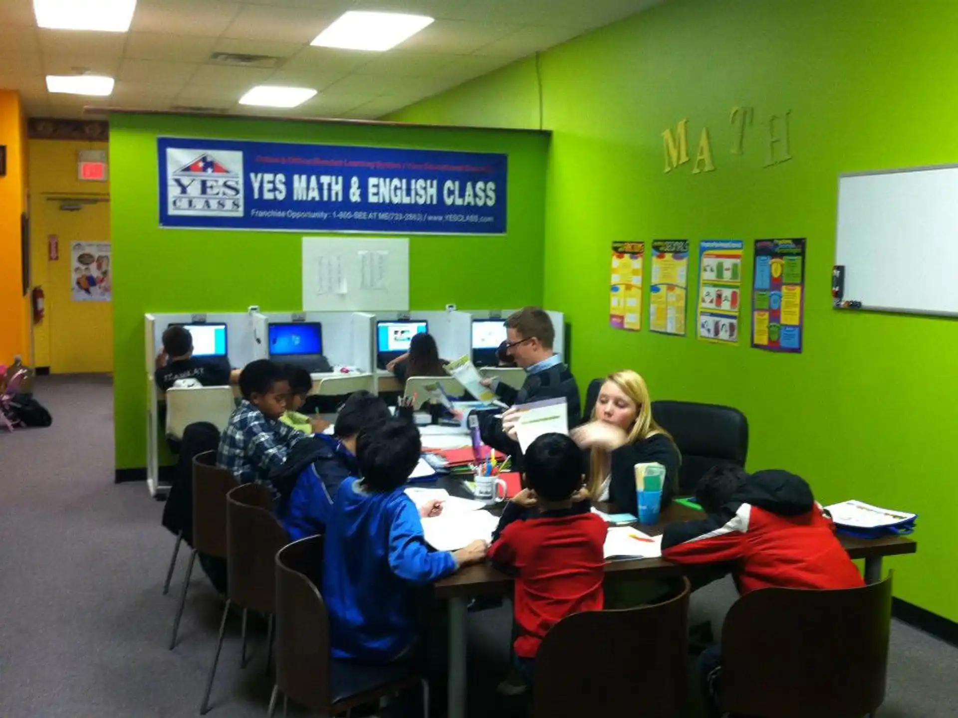 a group of people sitting at a table with computers