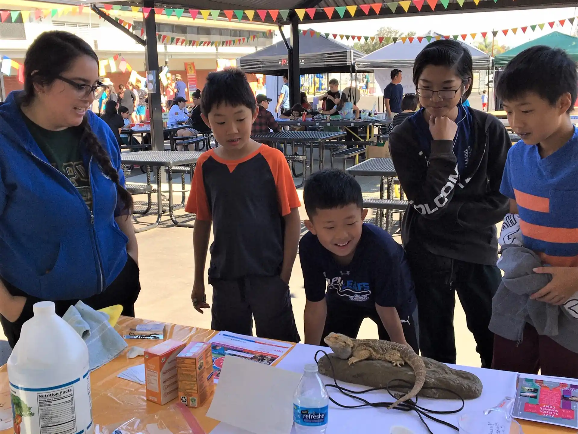 a group of people standing around a table with a fish on it