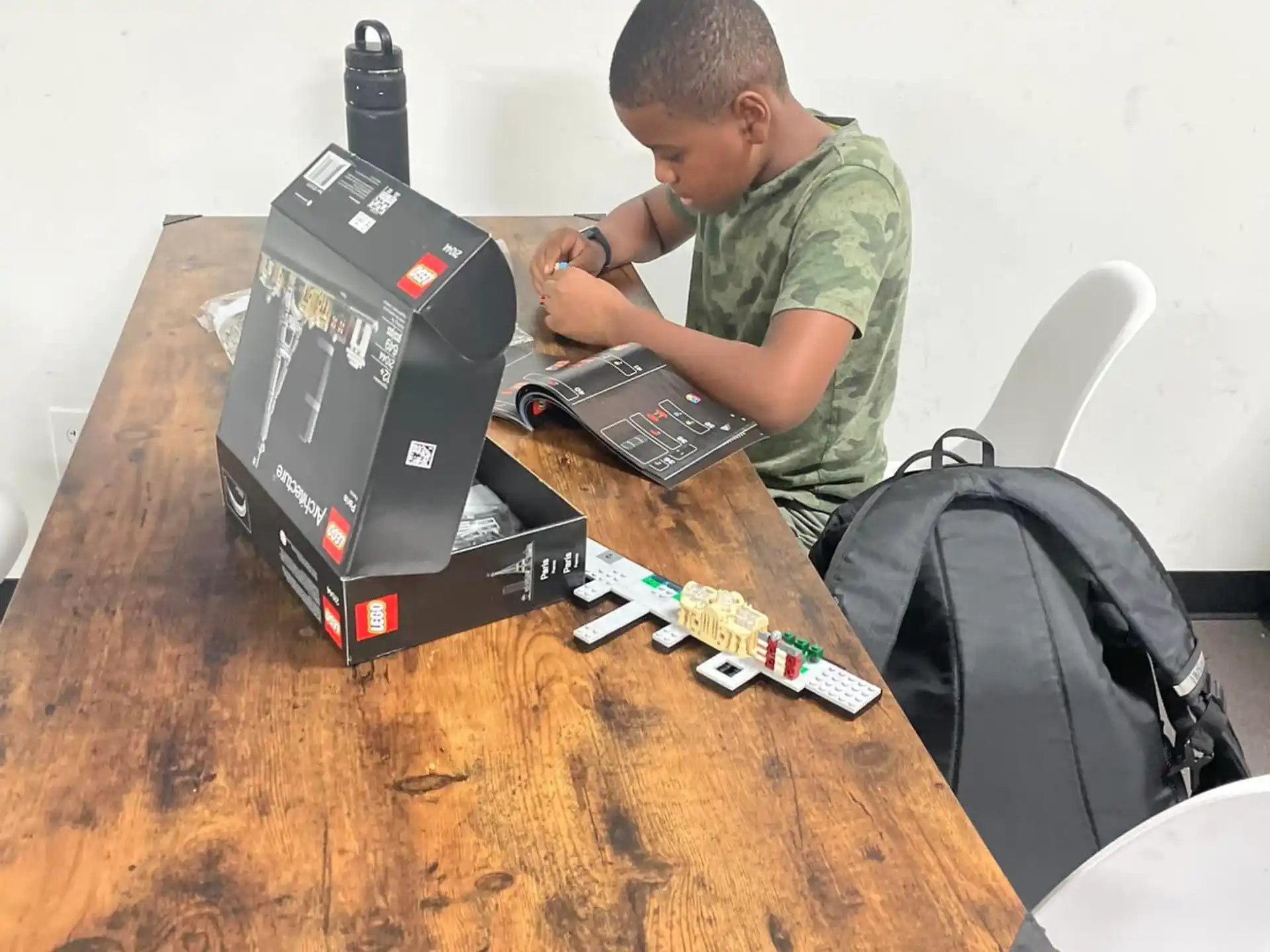 a man sitting at a table with a computer and a box