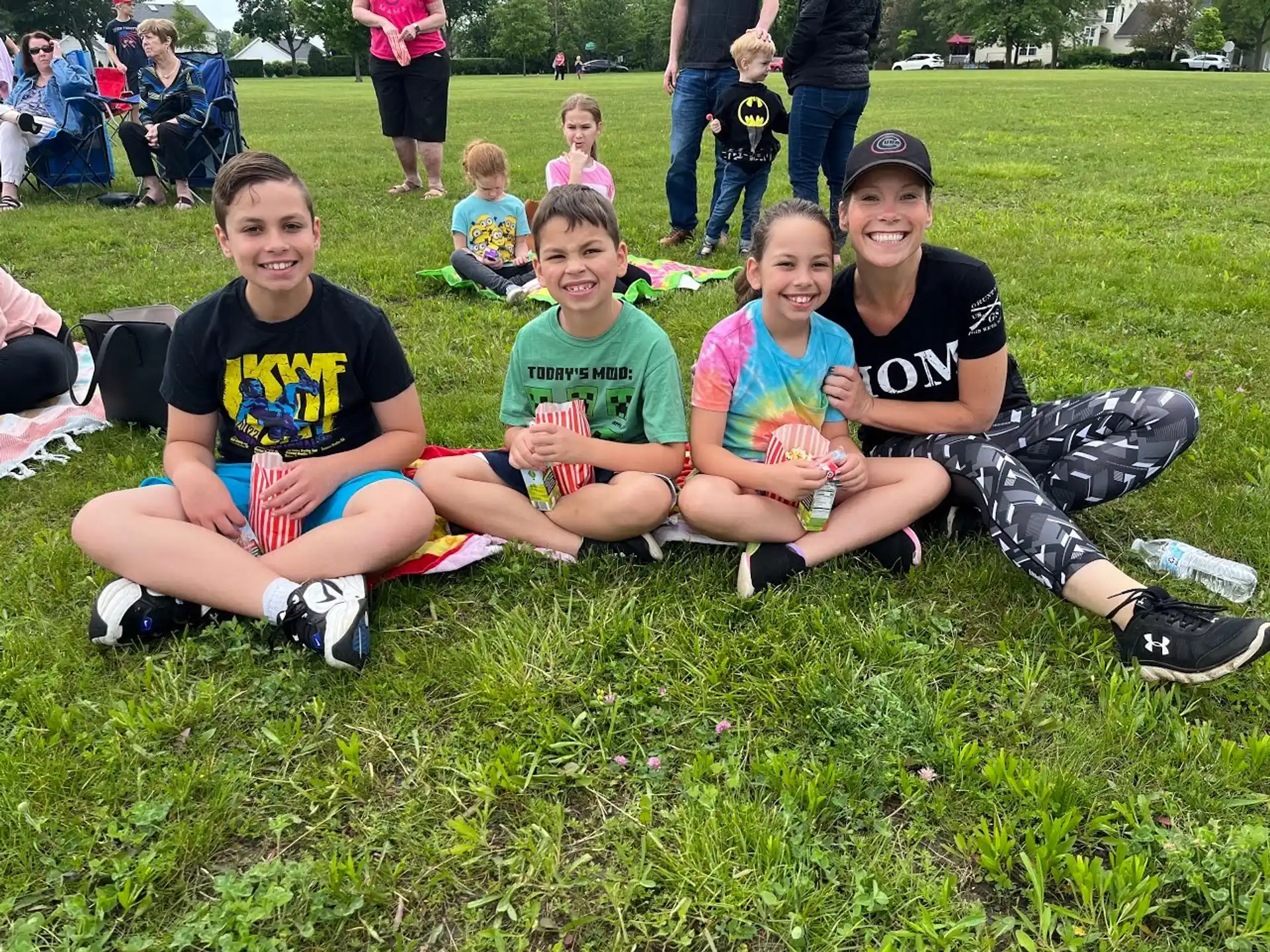 a group of kids sitting on the grass