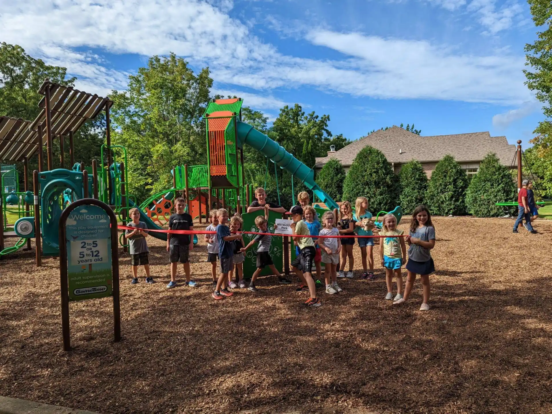 a group of people posing for a photo in front of a playground