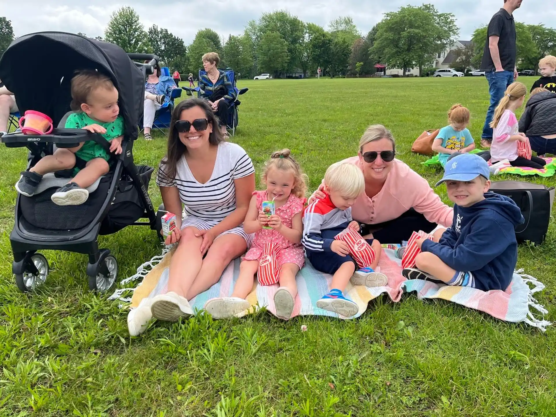 a group of people sitting on the grass