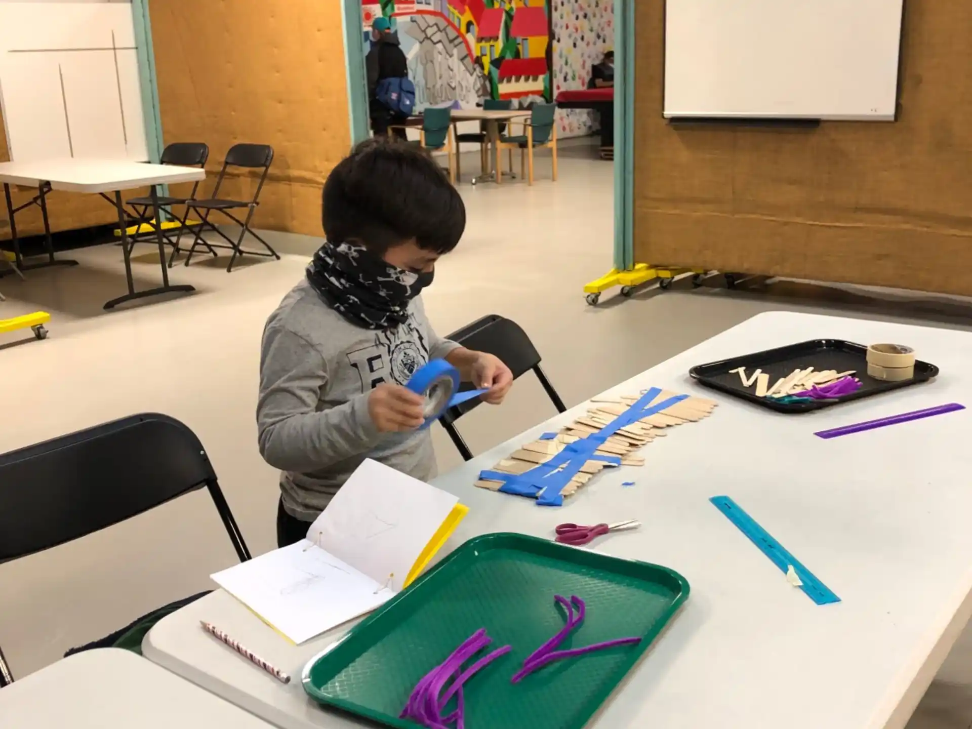 a person wearing headphones and writing on a white table