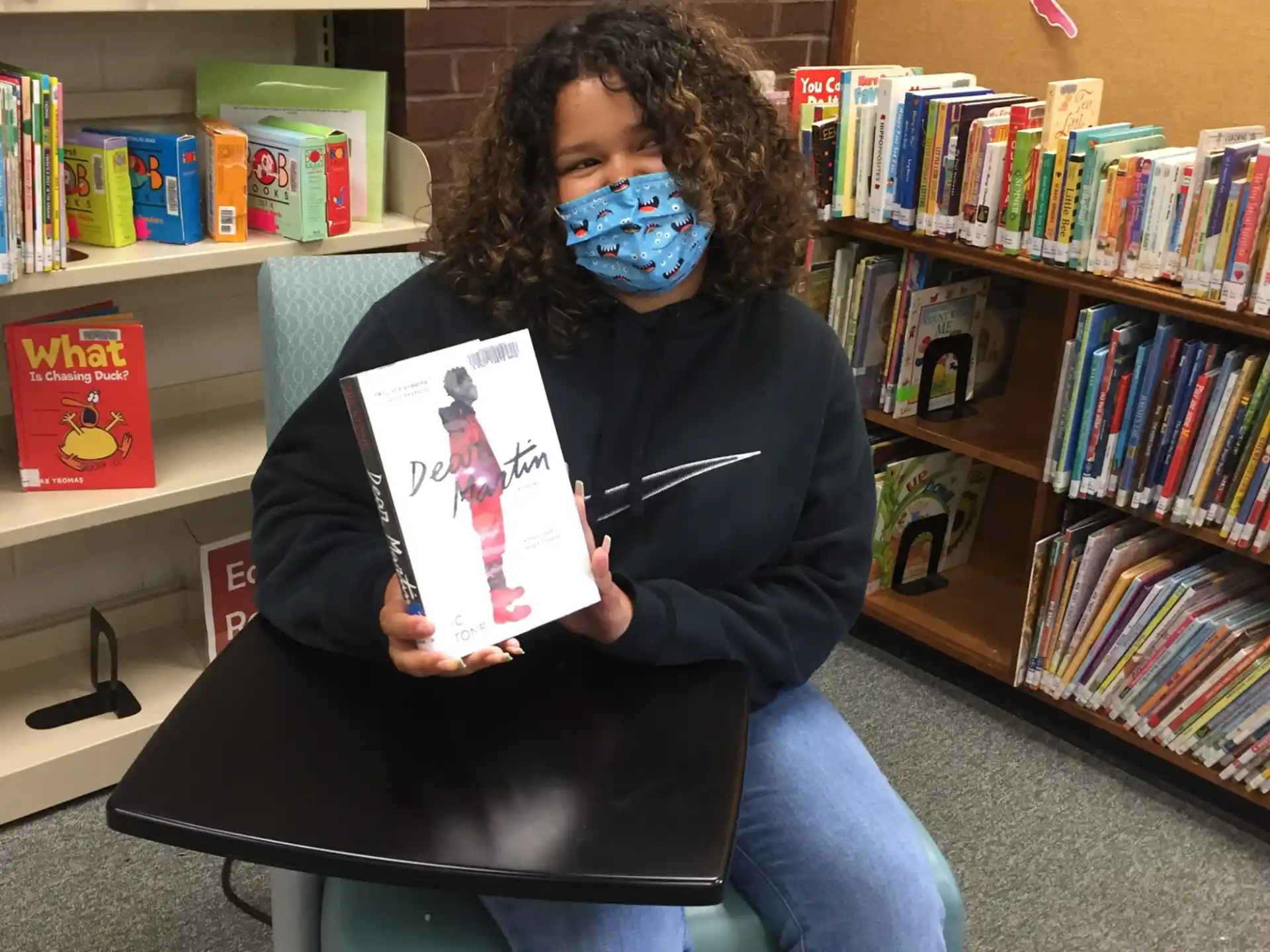 a person wearing a mask and holding a book