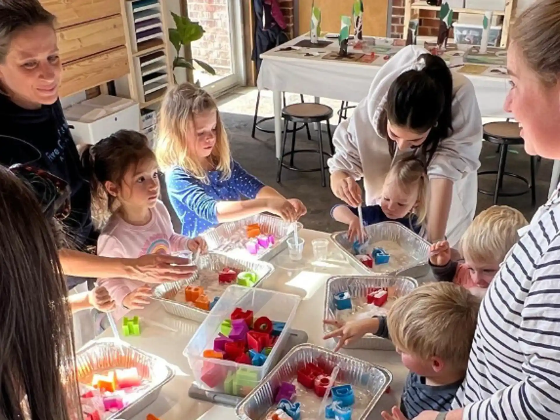 a group of children sitting around a table with food