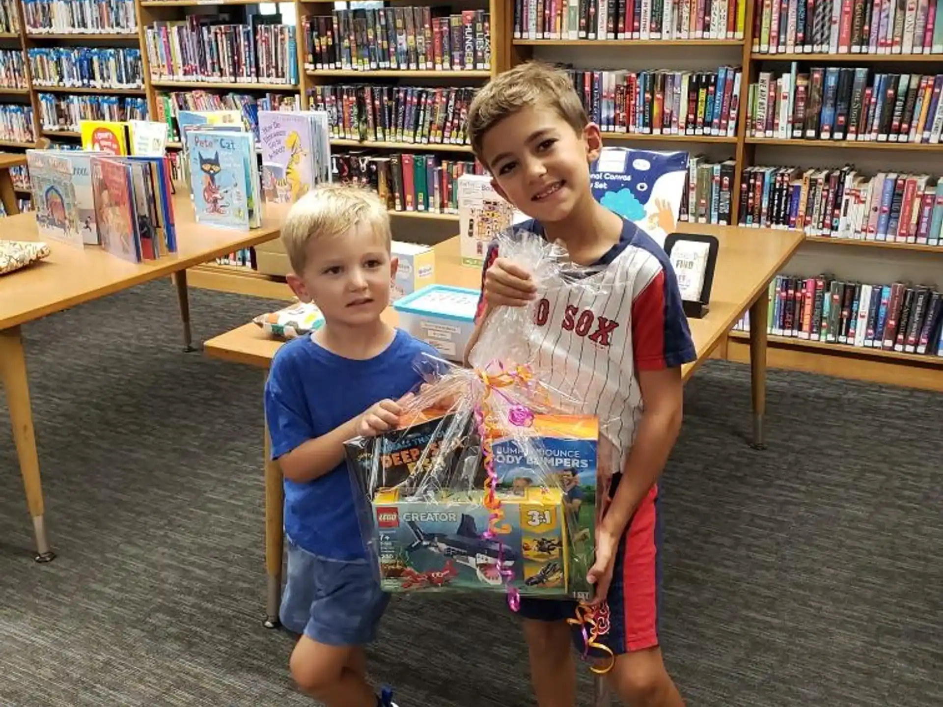 a couple of boys posing for the camera in a library