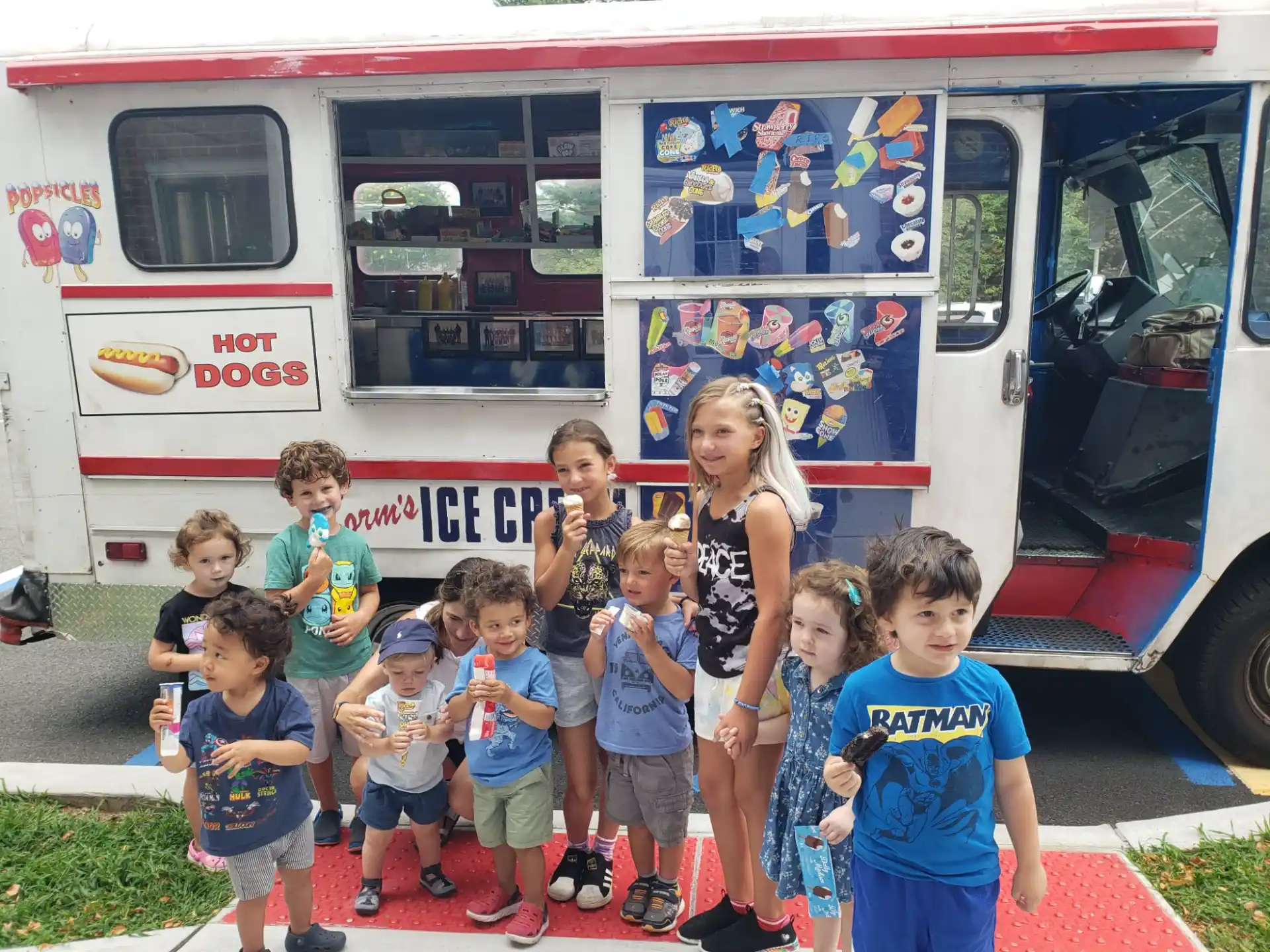 a group of children posing for a photo in front of a food truck