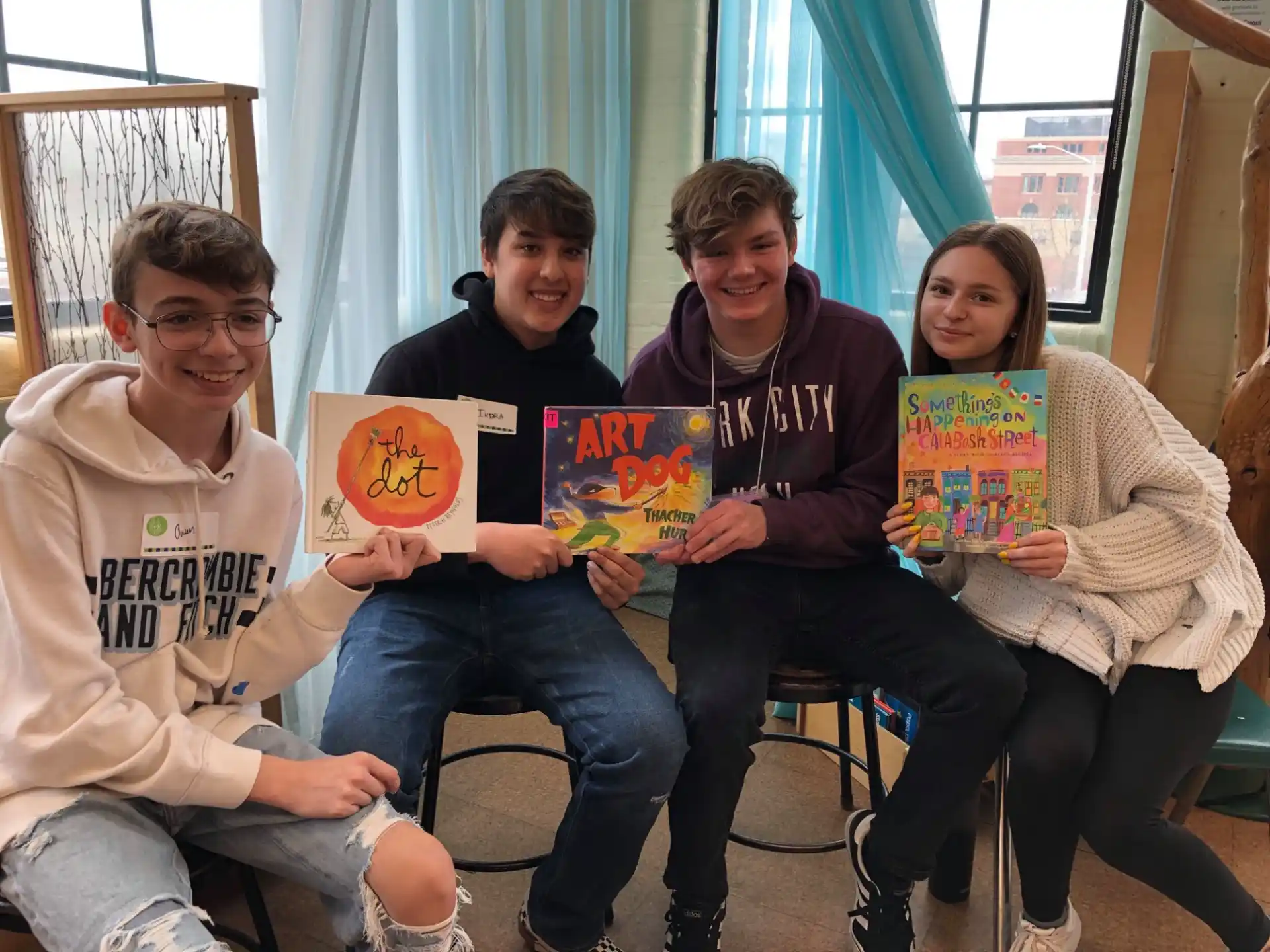 a group of people sitting on a couch holding books