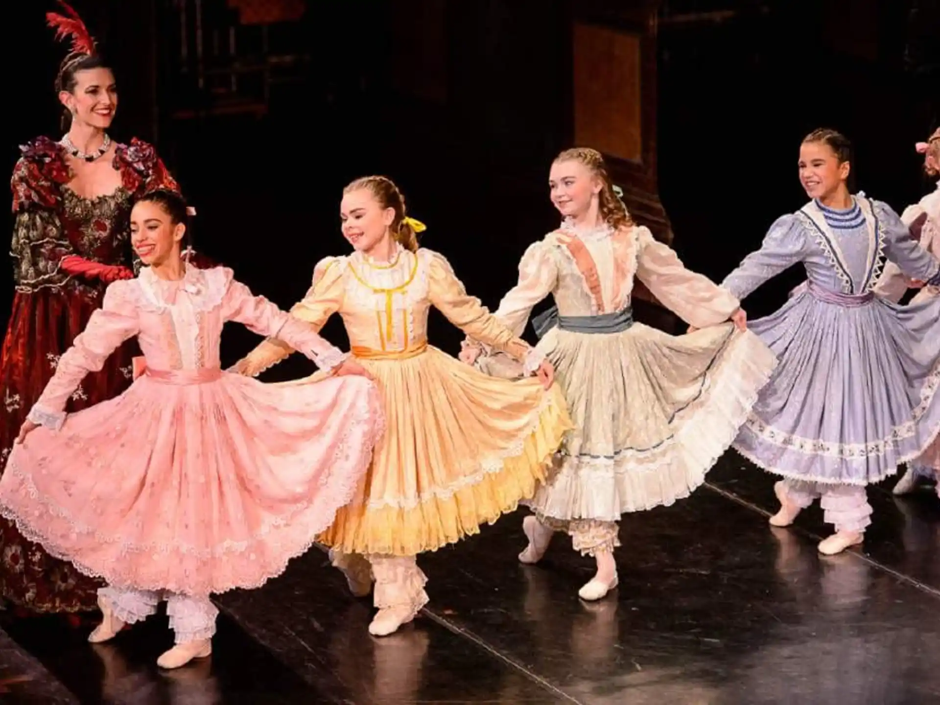 a group of girls in dresses dancing