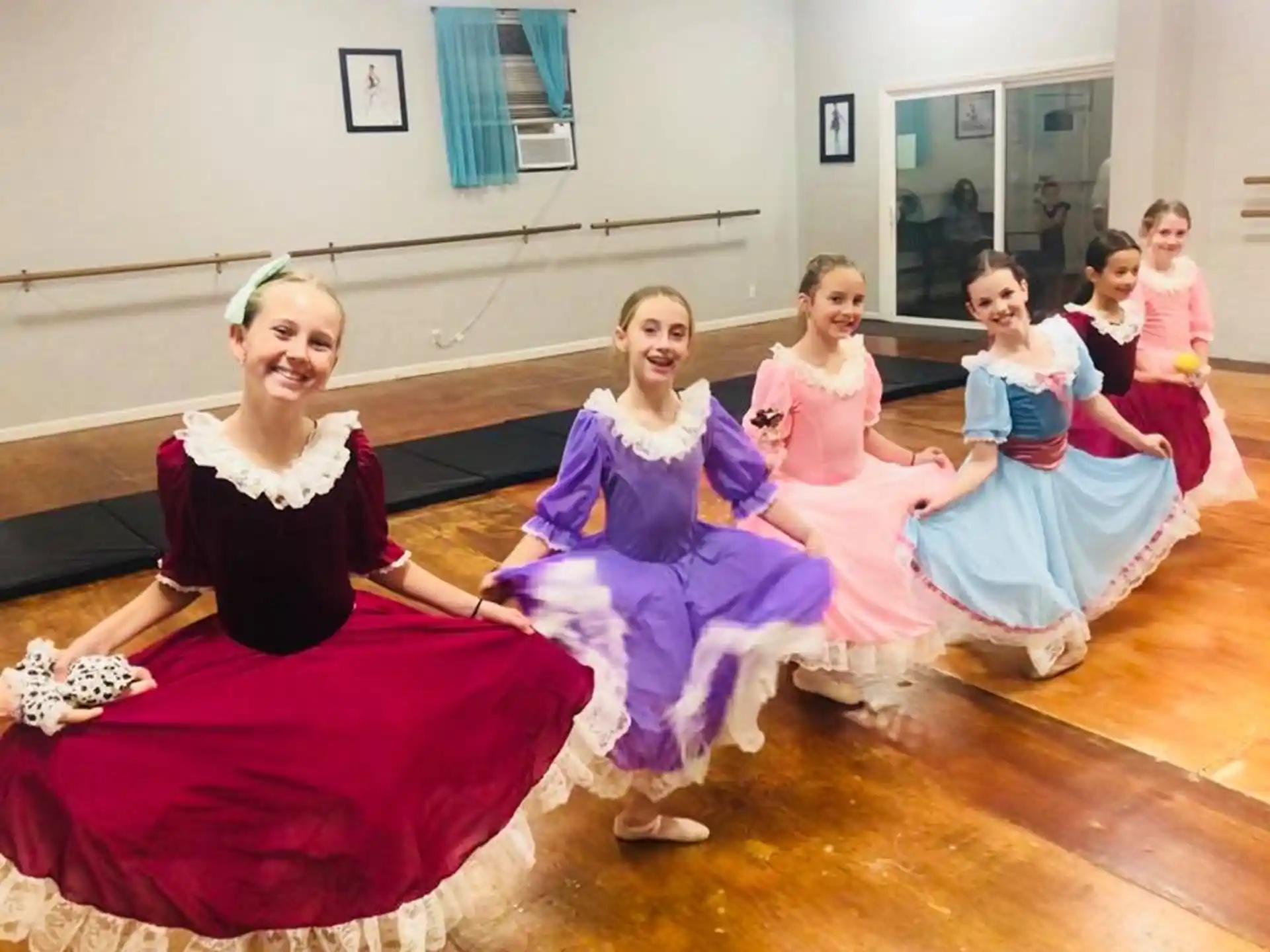 a group of women in dresses sitting on the floor