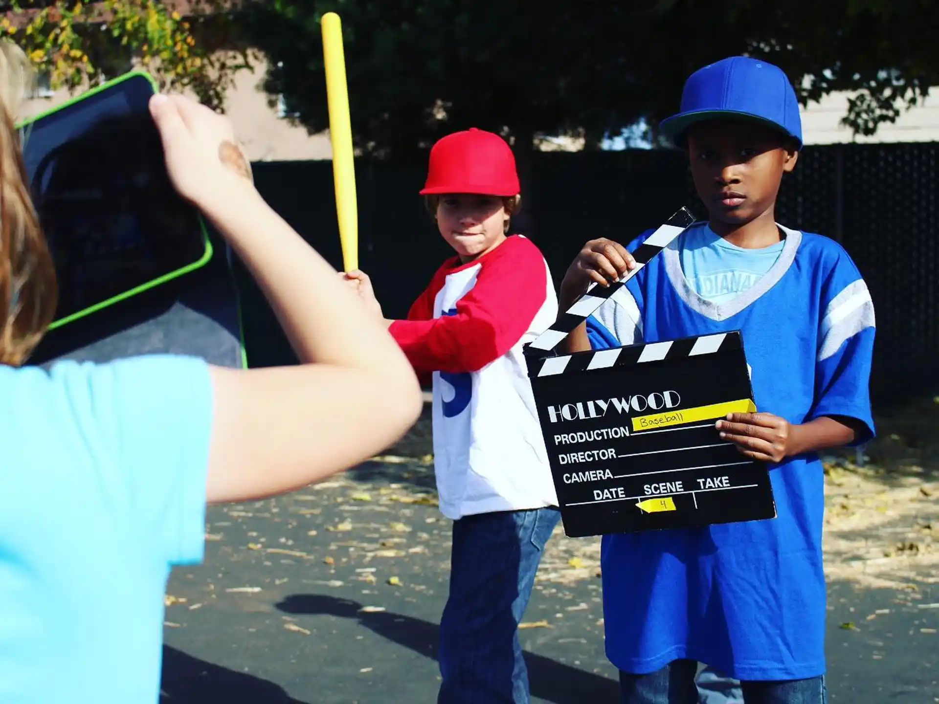 a person holding a sign with a boy holding a bat