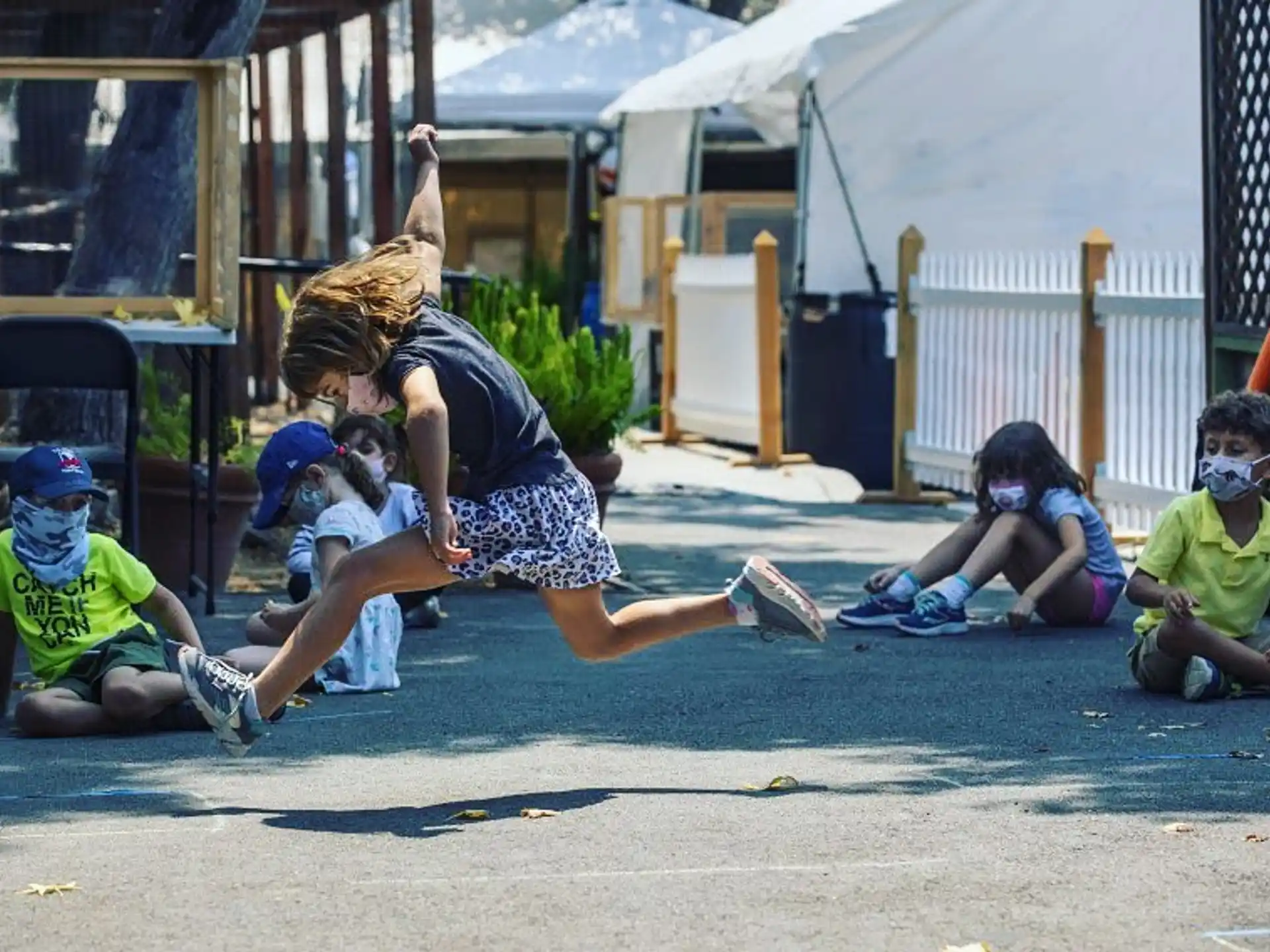 a person jumping in the air with kids around the