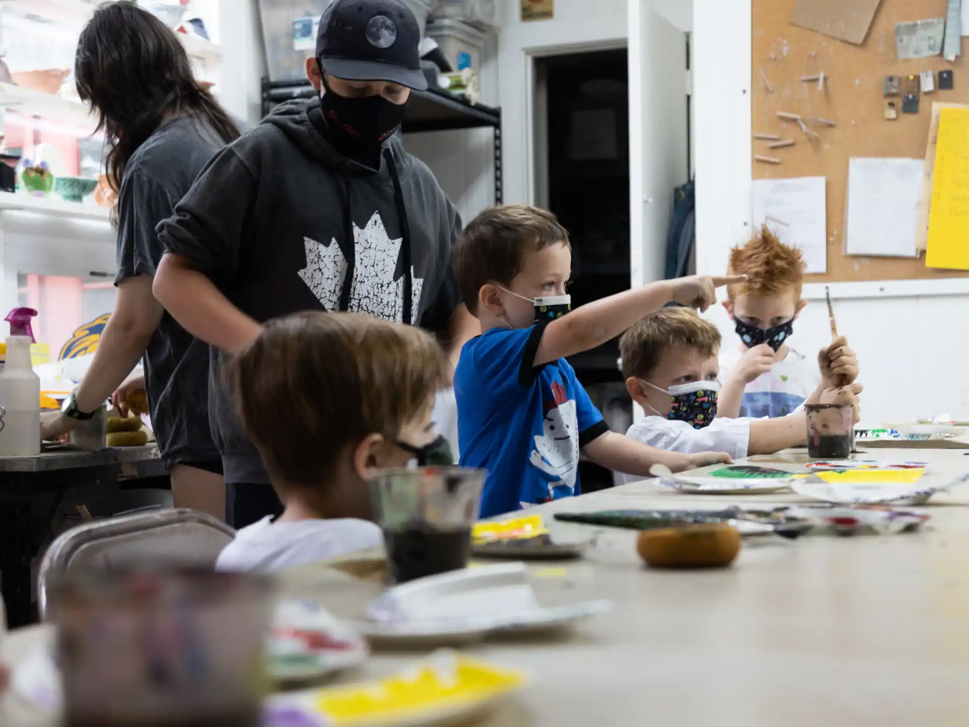 a group of kids sitting at a table with food and drinks