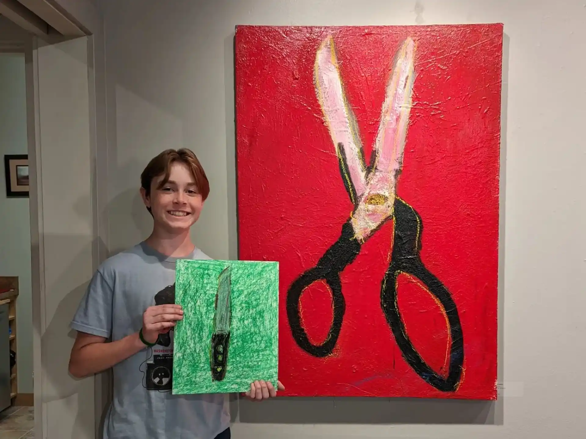 a man holding a bag and a camera in front of a painting