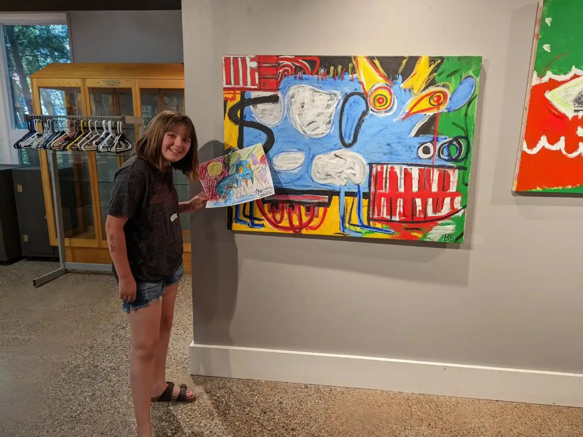 a person standing next to a painting