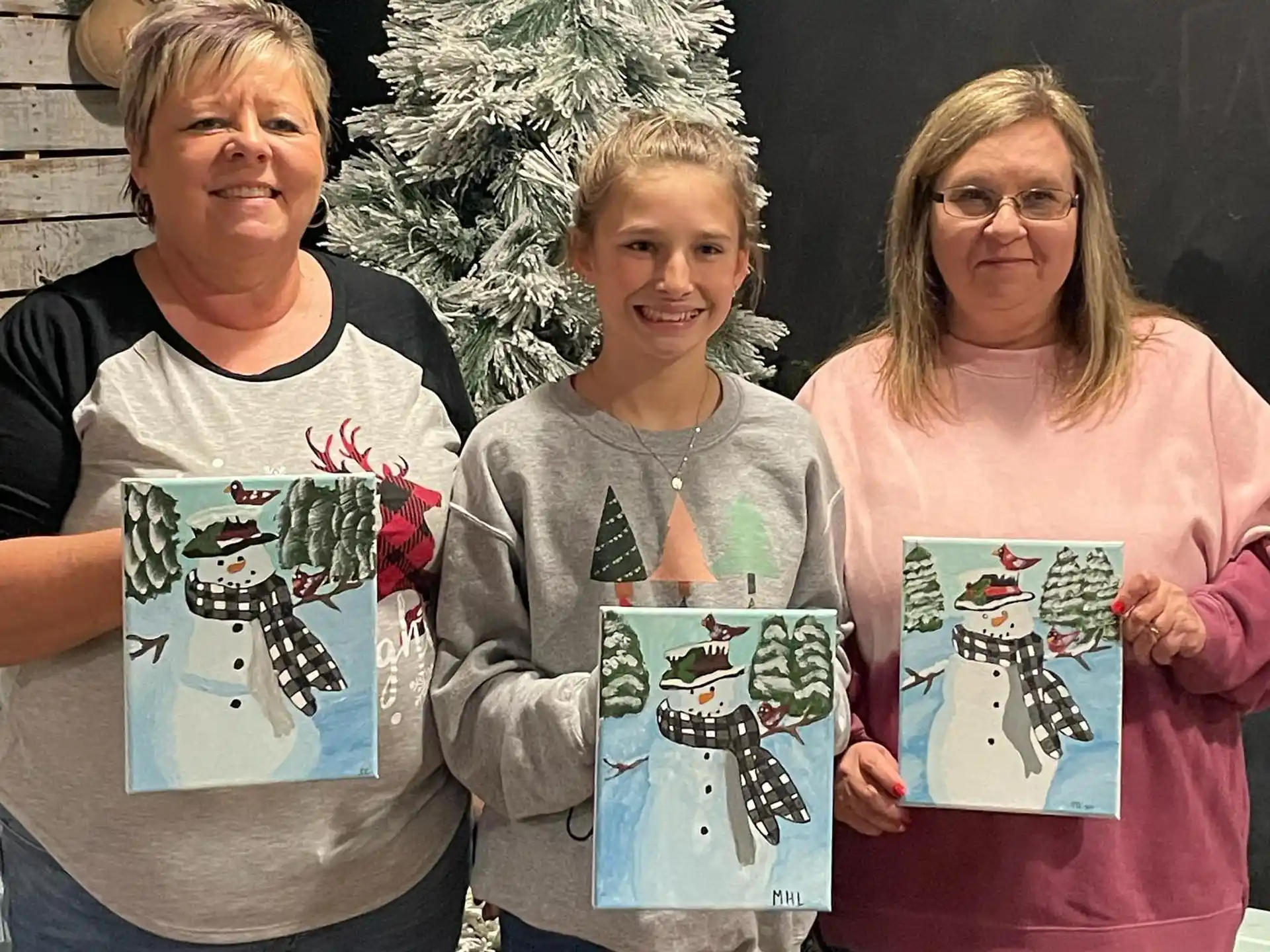 a group of people holding drawings
