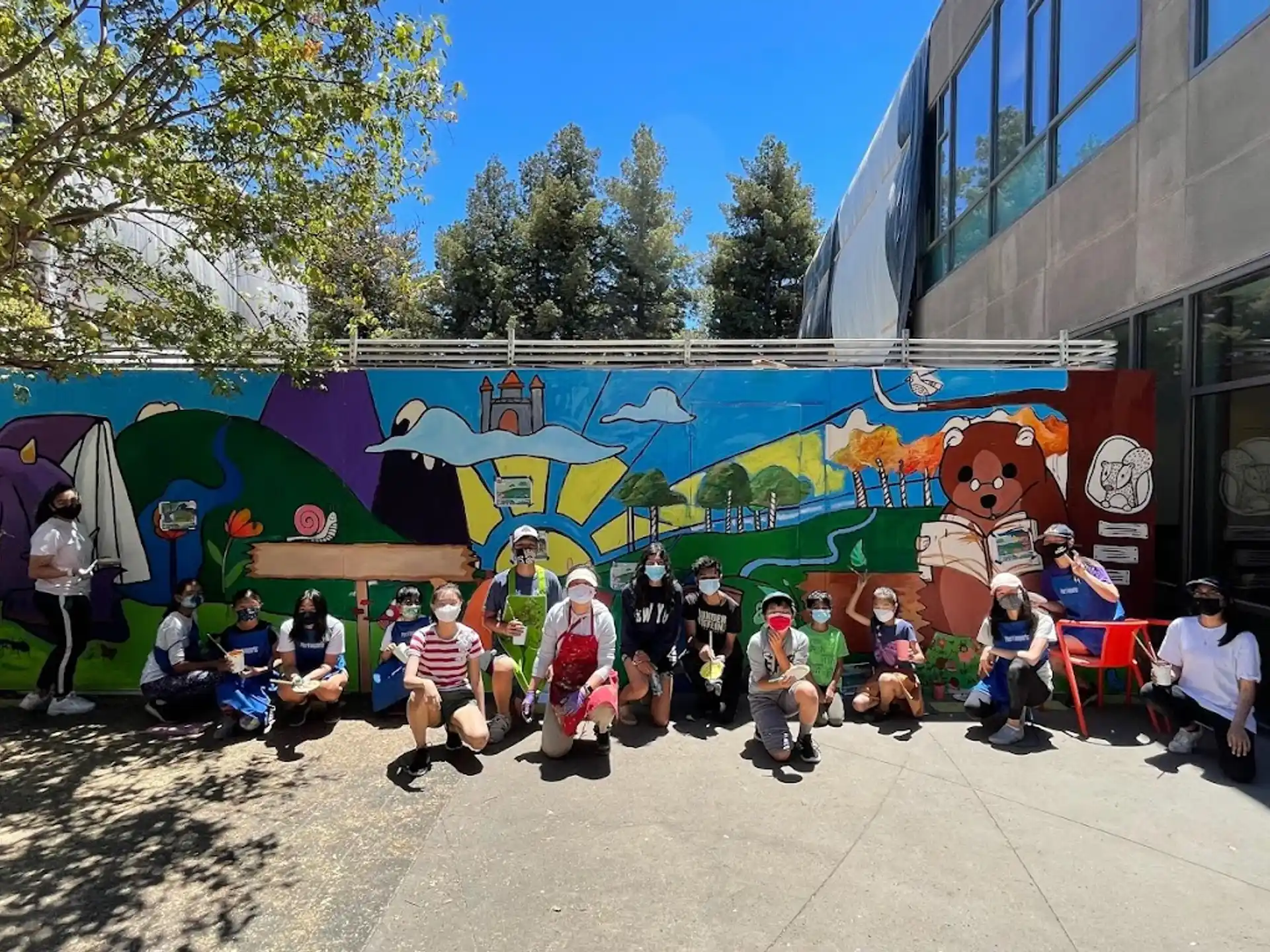 a group of people posing for a photo in front of a building