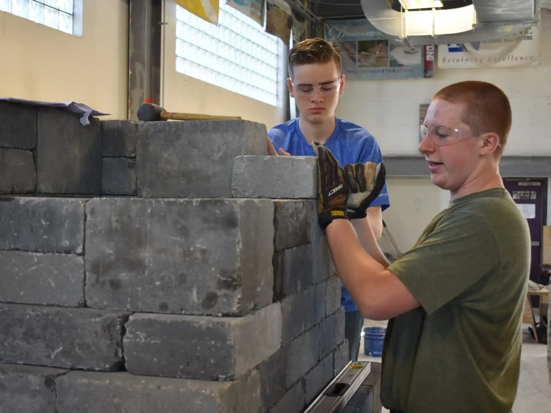 a person standing next to a person in a room with a brick wall