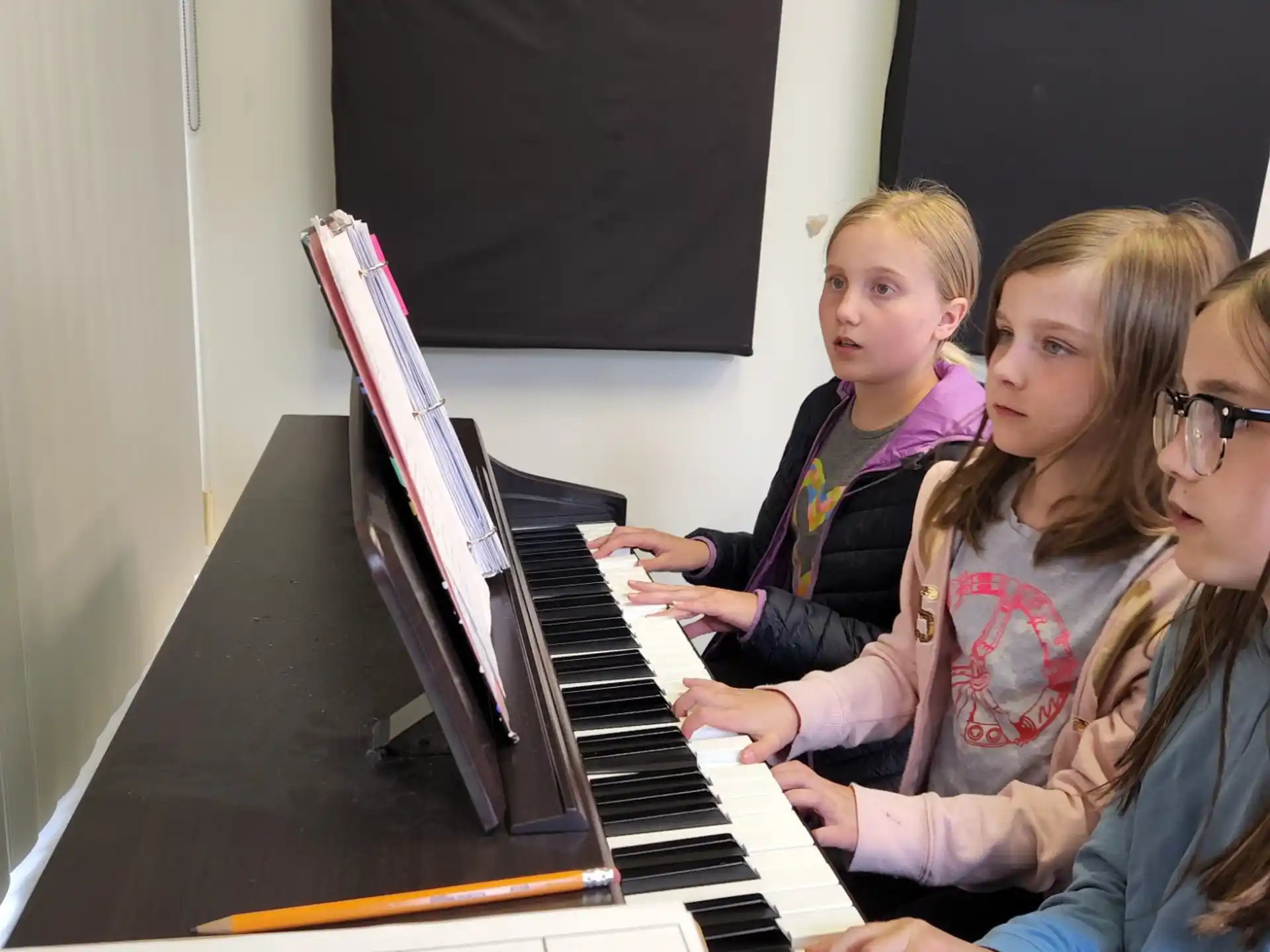 a group of girls playing piano