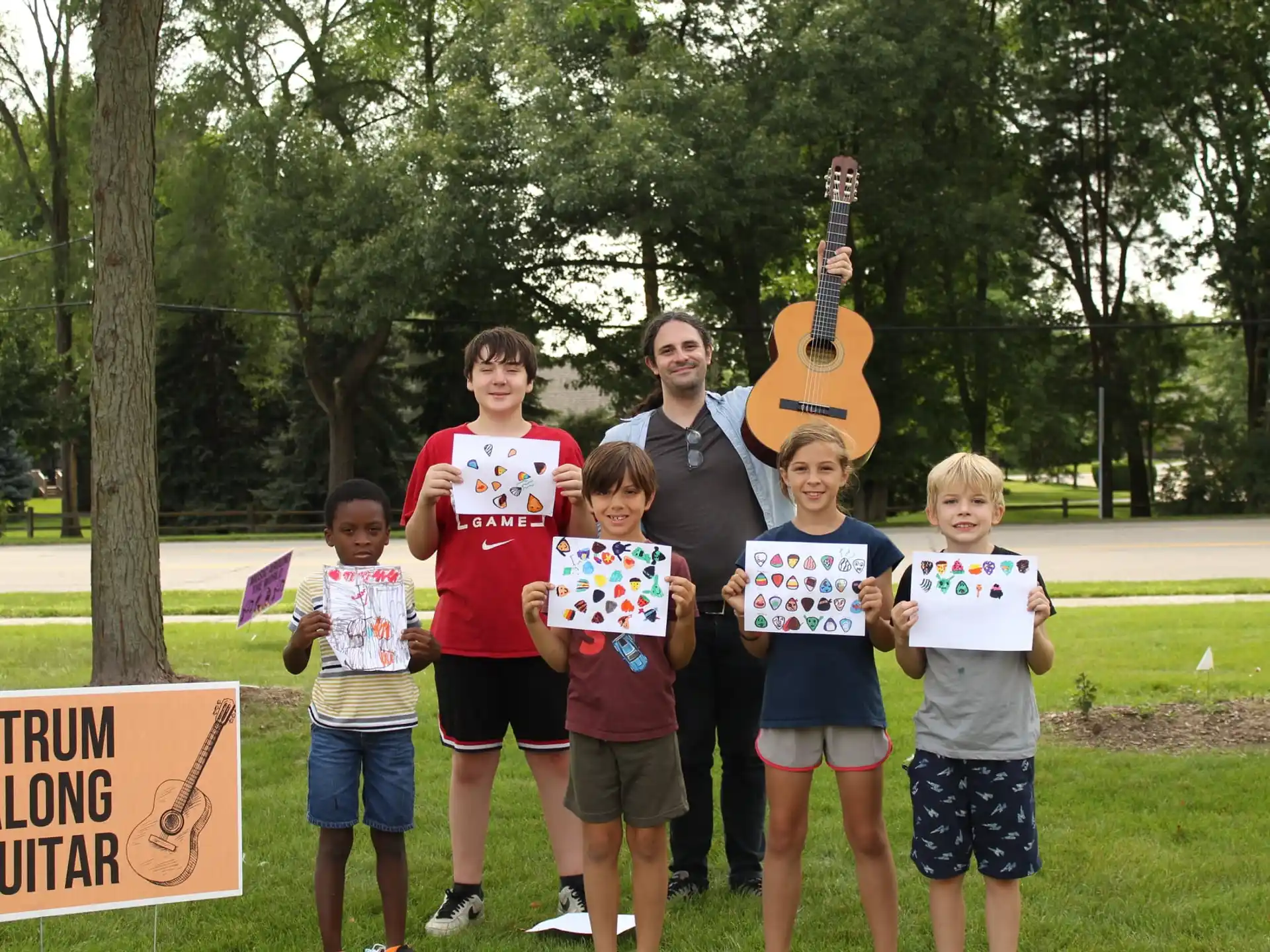a group of people posing for a photo with a guitar