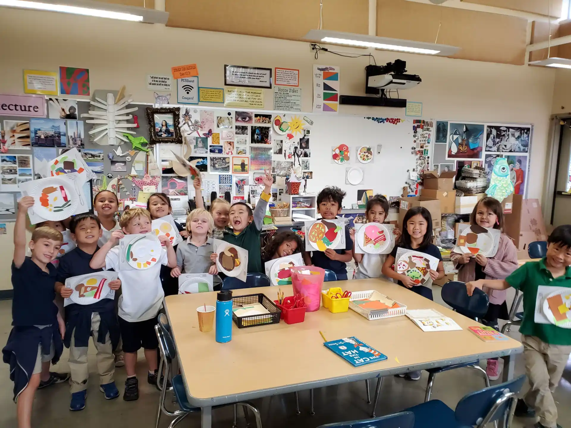 a group of children holding up colorful paper cups