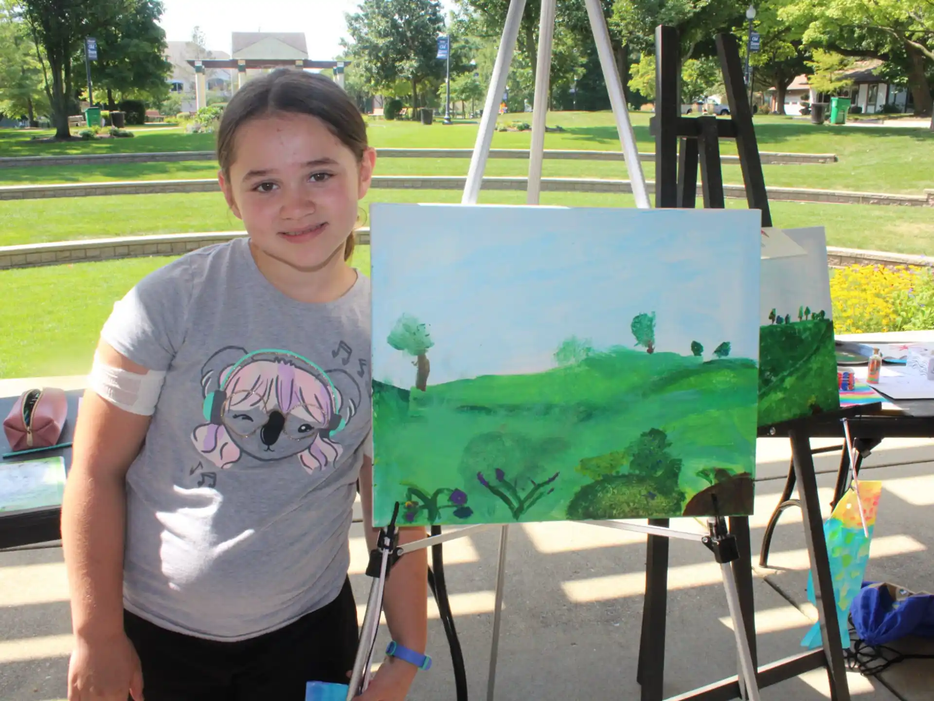 a boy standing next to a painting
