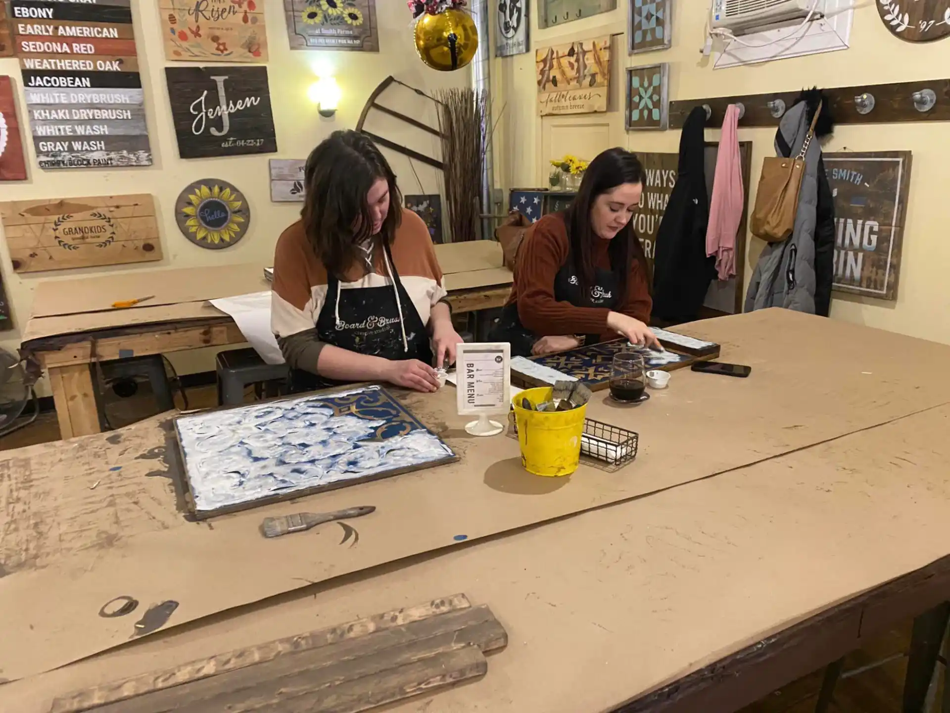 a couple of women sitting at a table with a book and a pencil
