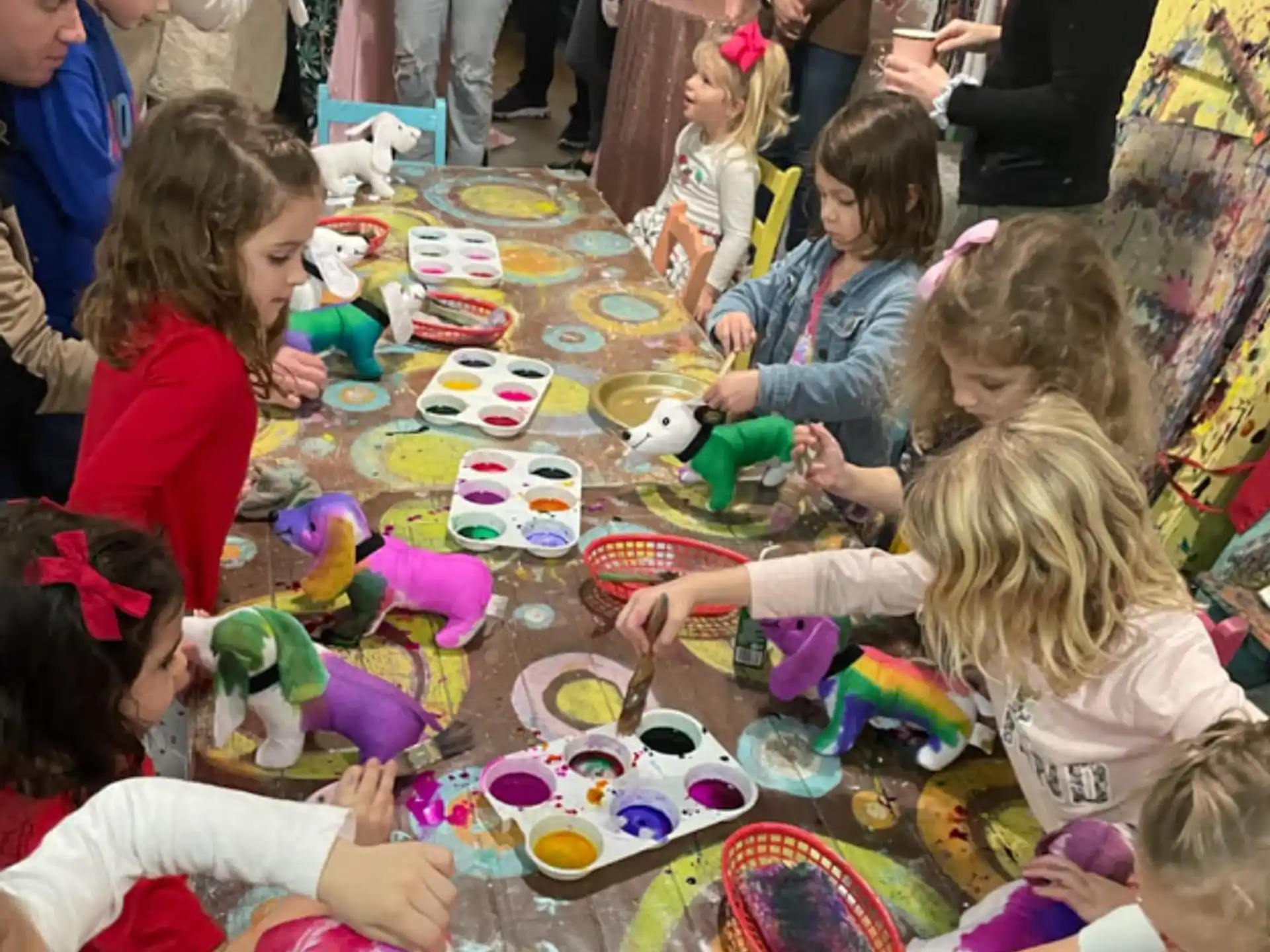 a group of children sitting around a table with food on it