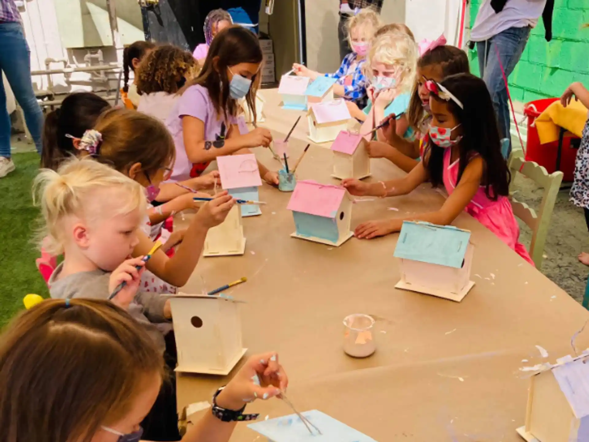 a group of children sitting at a table writing on paper