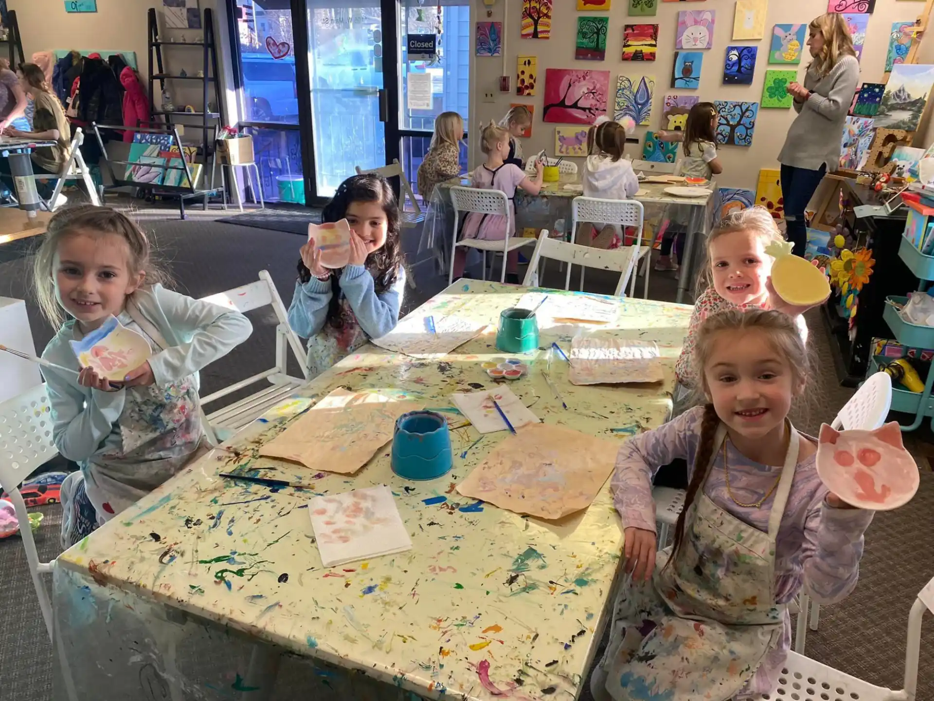a group of children sitting at a table with food and drinks