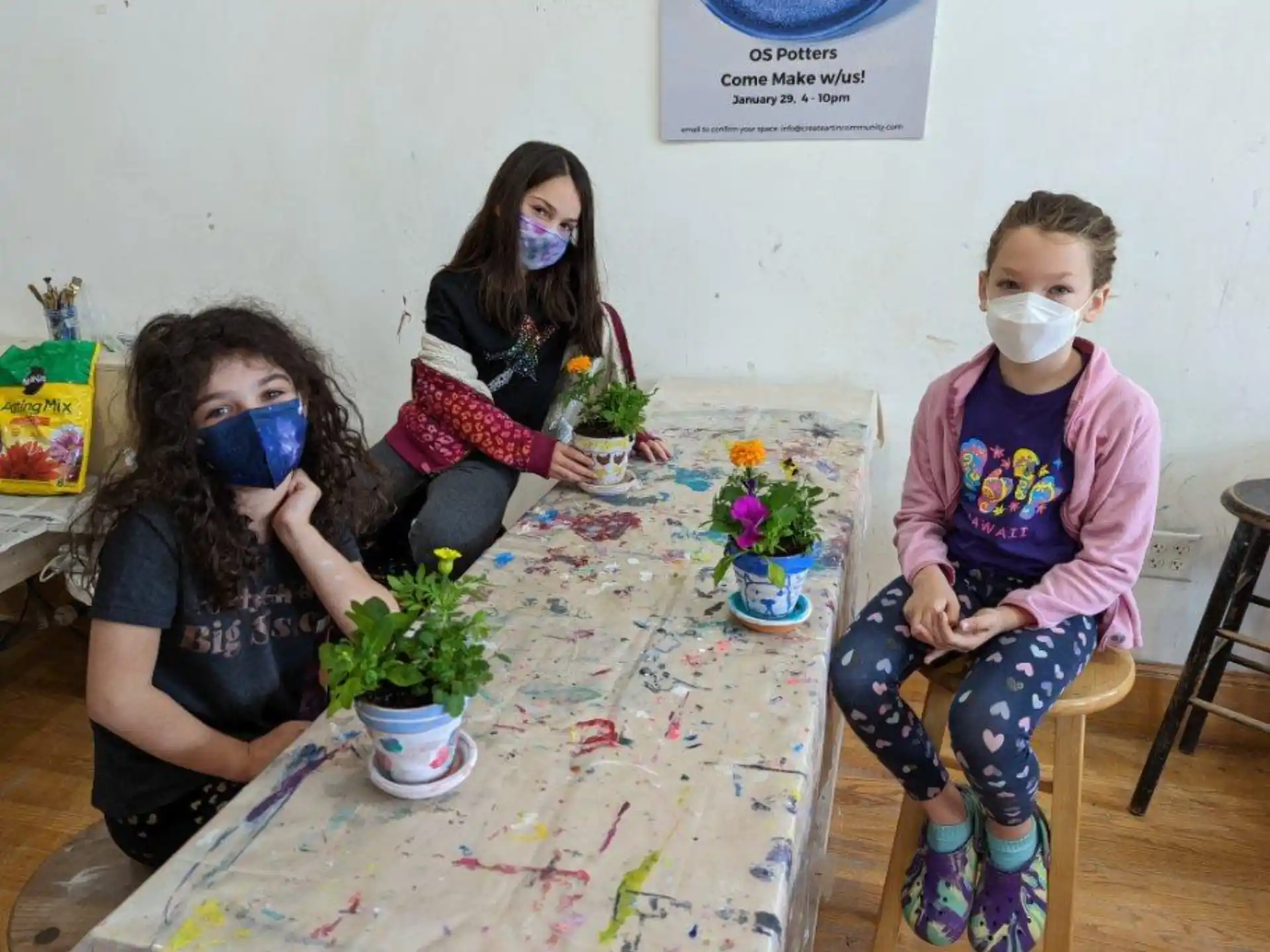 a group of people sitting at a table with masks on