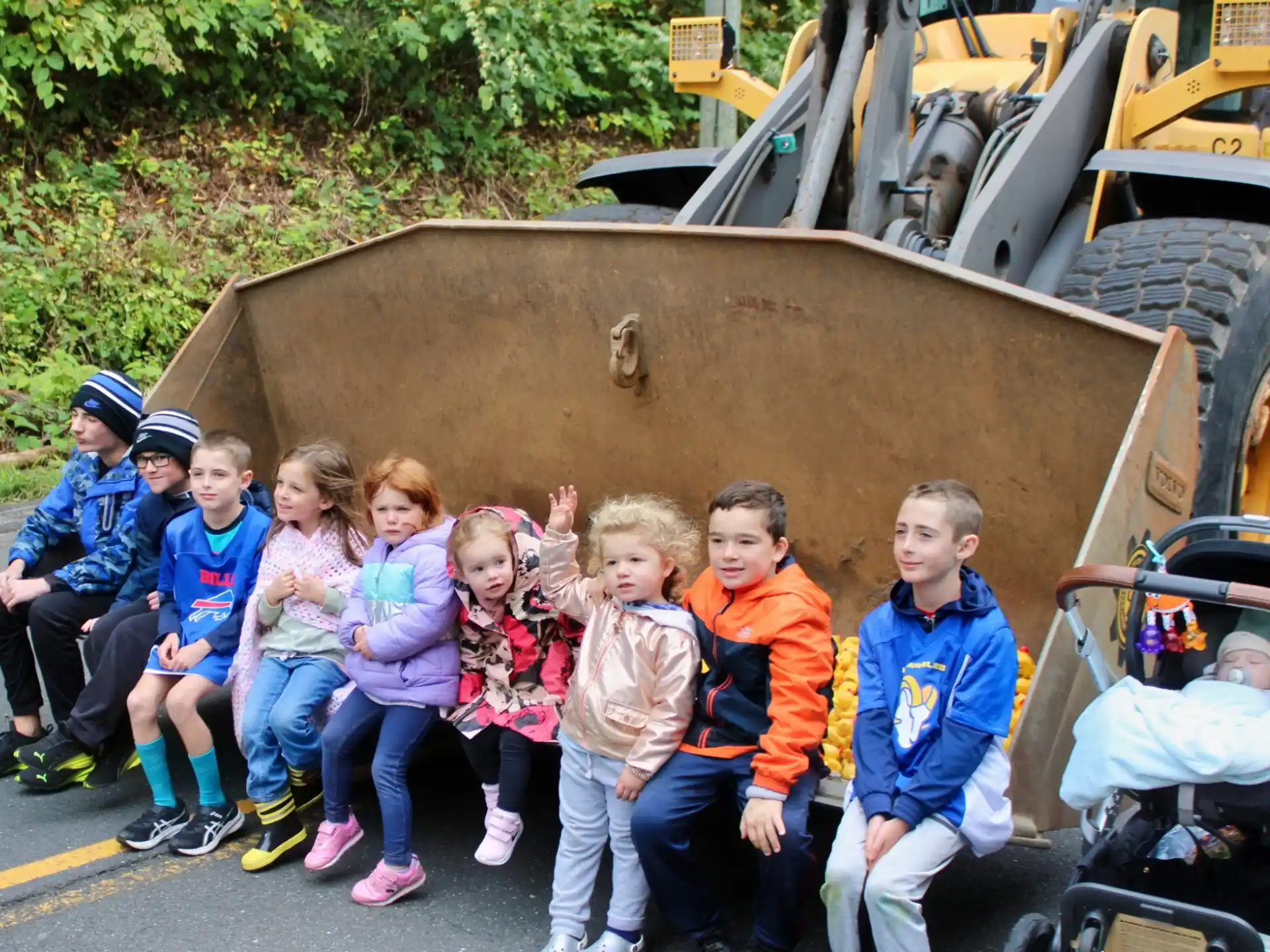 a group of children posing for a photo in front of a tractor