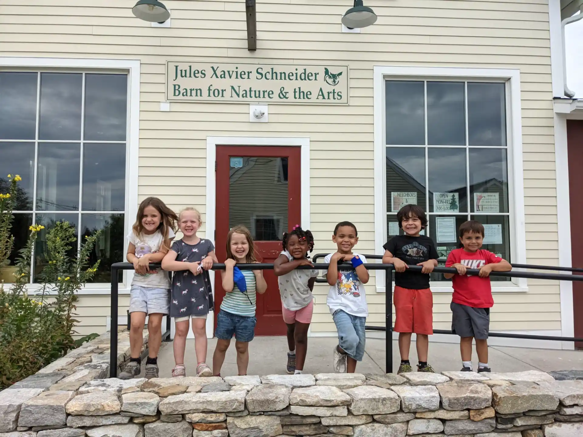 a group of children posing for a photo outside of a building